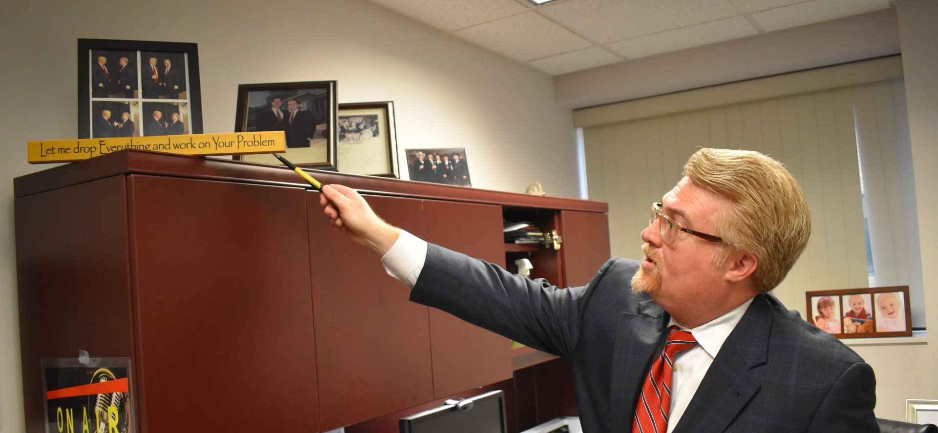 Attorney Marc Scaringi points to photos of him with Republican President Donald Trump during an interview on April 25, 2019, in his Dauphin County office.