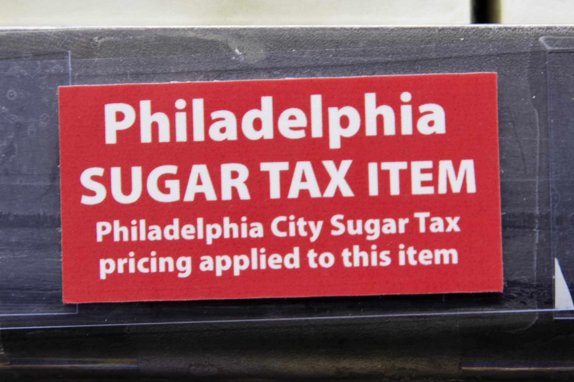 This March 16, 2017 photo shows a sticker alerting customers of the sugar tax posted by sweetened beverages at the IGA supermarket in the Port Richmond neighborhood of Philadelphia.