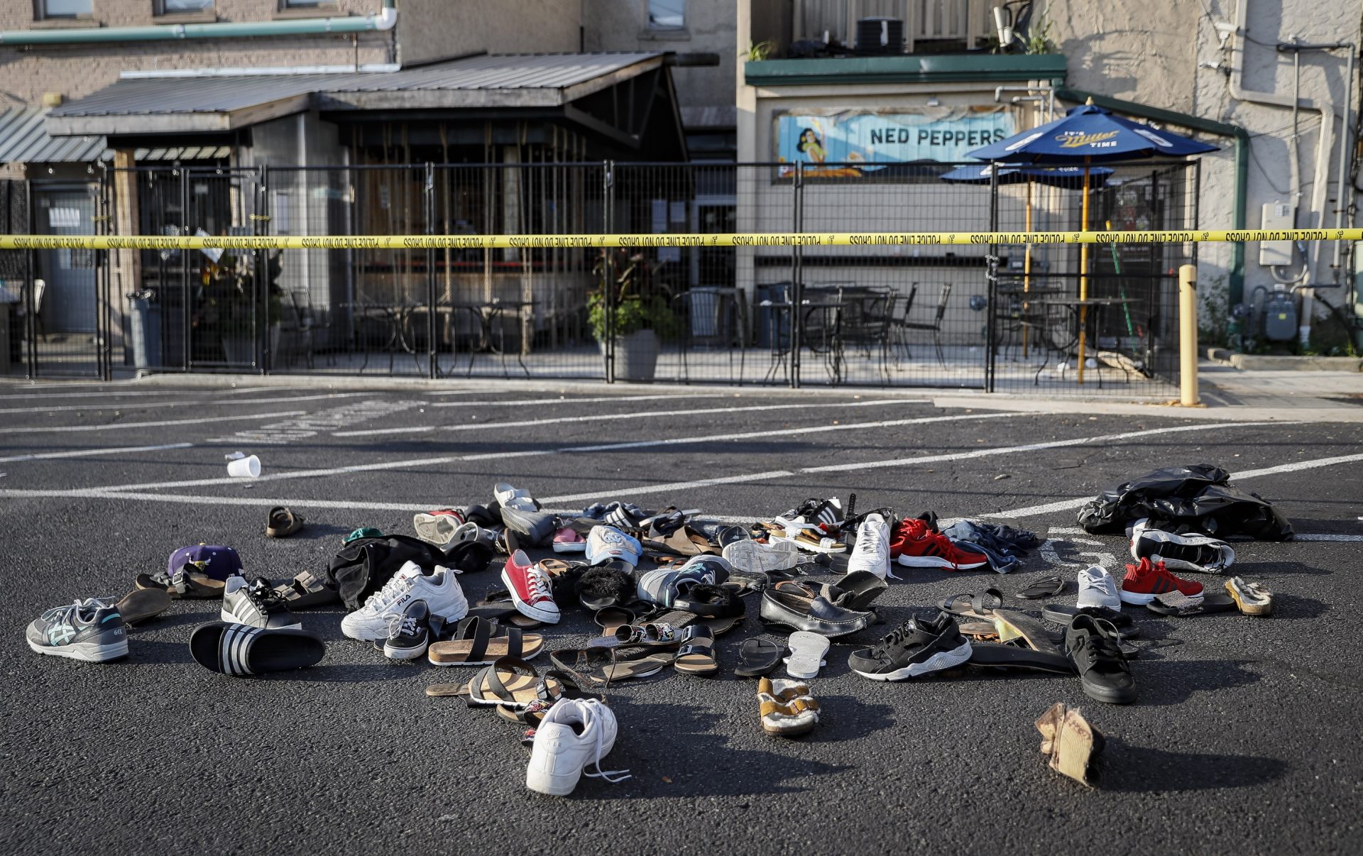 FILE PHOTO: This Aug. 4, 2019 file photo shows shoes piled outside the scene of a mass shooting around Ned Peppers bar that killed multiple people in Dayton, Ohio. The FBI has labeled two of those attacks, at a Texas Walmart and California food festival, as domestic terrorism — acts meant to intimidate or coerce a civilian population and affect government policy.