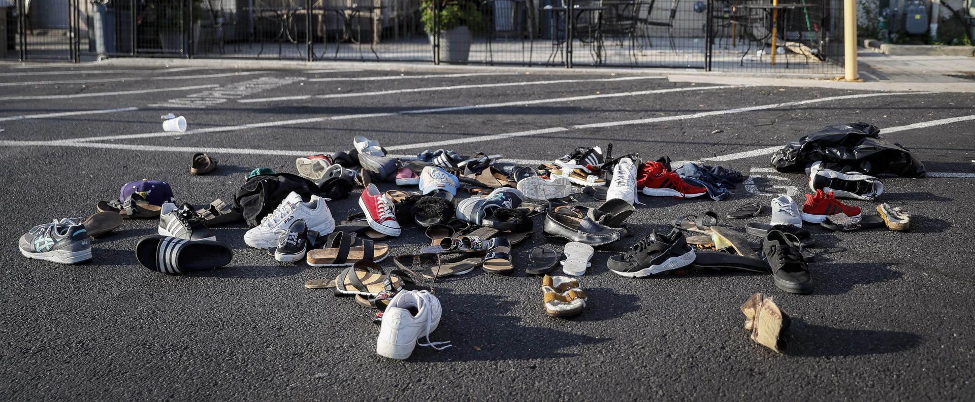 FILE PHOTO: This Aug. 4, 2019 file photo shows shoes piled outside the scene of a mass shooting around Ned Peppers bar that killed multiple people in Dayton, Ohio. The FBI has labeled two of those attacks, at a Texas Walmart and California food festival, as domestic terrorism — acts meant to intimidate or coerce a civilian population and affect government policy.