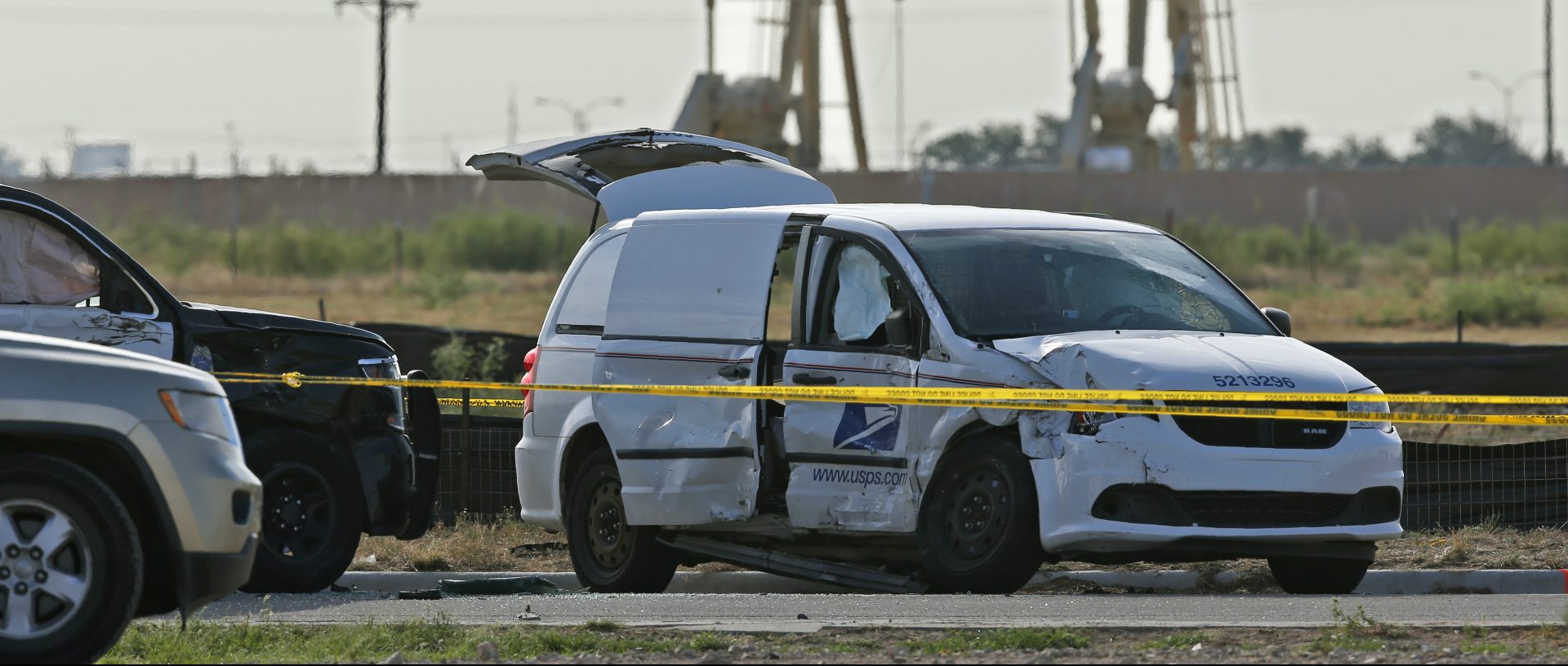 A U.S. Mail vehicle, right, which was involved in Saturday's shooting, is pictured outside the Cinergy entertainment center Sunday, Sept. 1, 2019, in Odessa, Texas. The death toll in the West Texas shooting rampage increased Sunday as authorities investigated why a man stopped by state troopers for failing to signal a left turn opened fire on them and fled, shooting over a dozen people as he drove before being killed by officers outside a movie theater. A police vehicle is partially blocked at left.