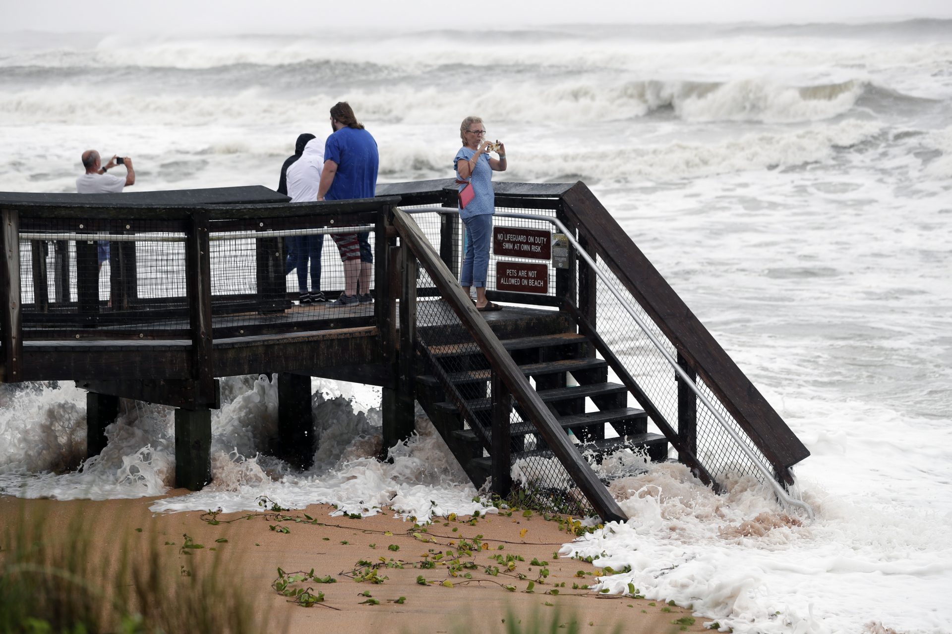 Sightseers watch waves crash on shore as Hurricane Dorian made its way off the Florida coast Wednesday, Sept. 4, 2019, in Ormond-by-the-Sea, Fla.