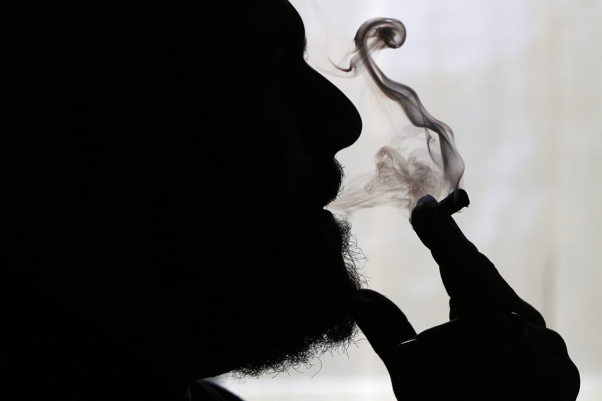 FILE PHOTO: In this Nov. 21, 2014 file photo, a man smokes medical marijuana at his home in Belfast, Maine. Sniff and search is no longer the default for police in some of the 33 states that have legalized marijuana. Traditionally, an officer could use the merest whiff of weed to justify a warrantless vehicle search, and whatever turned up could be used as evidence in court.