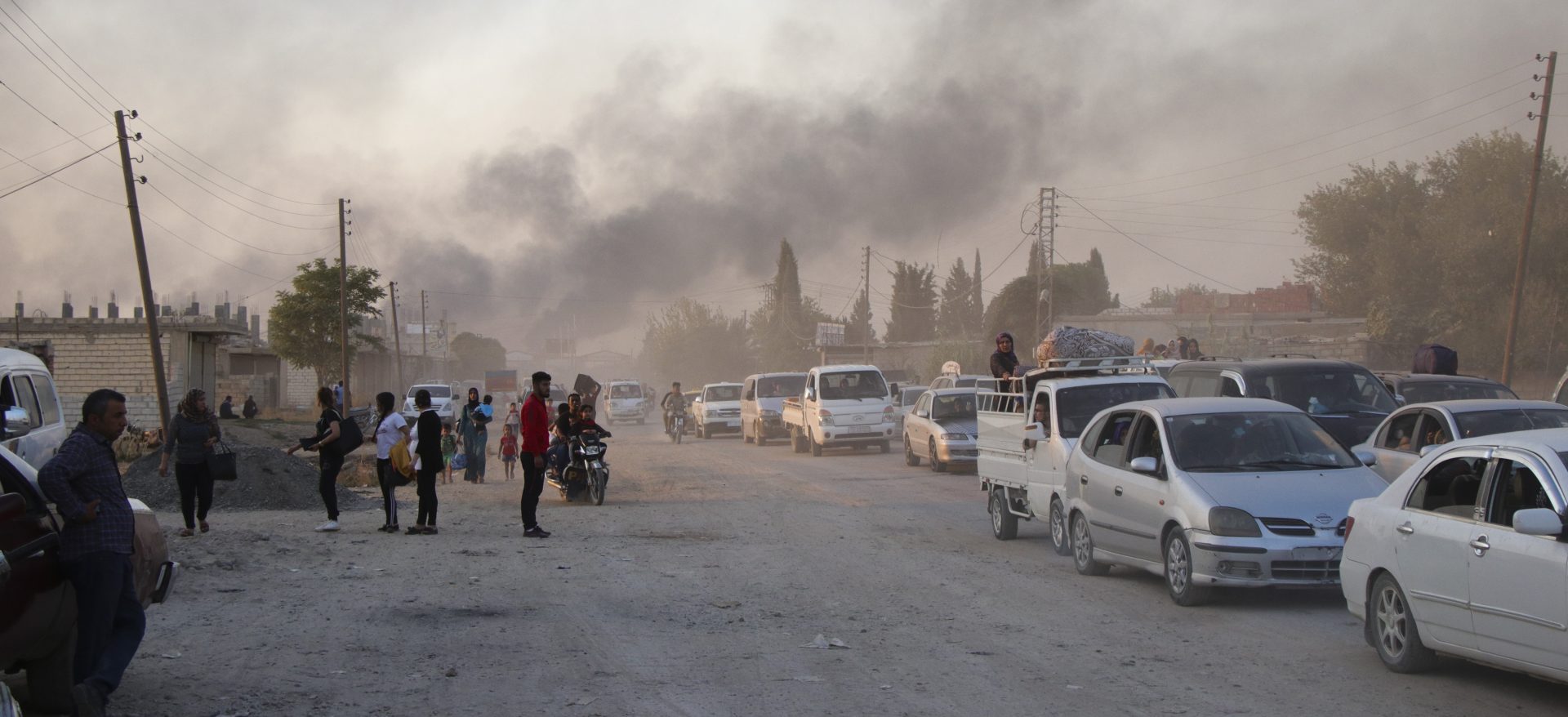 Syrians flee shelling by Turkish forces in Ras al Ayn, northeast Syria, Wednesday, Oct. 9, 2019. Turkish President Recep Tayyip Erdogan announced Wednesday the start of a Turkish military operation against Kurdish fighters in northeastern Syria.