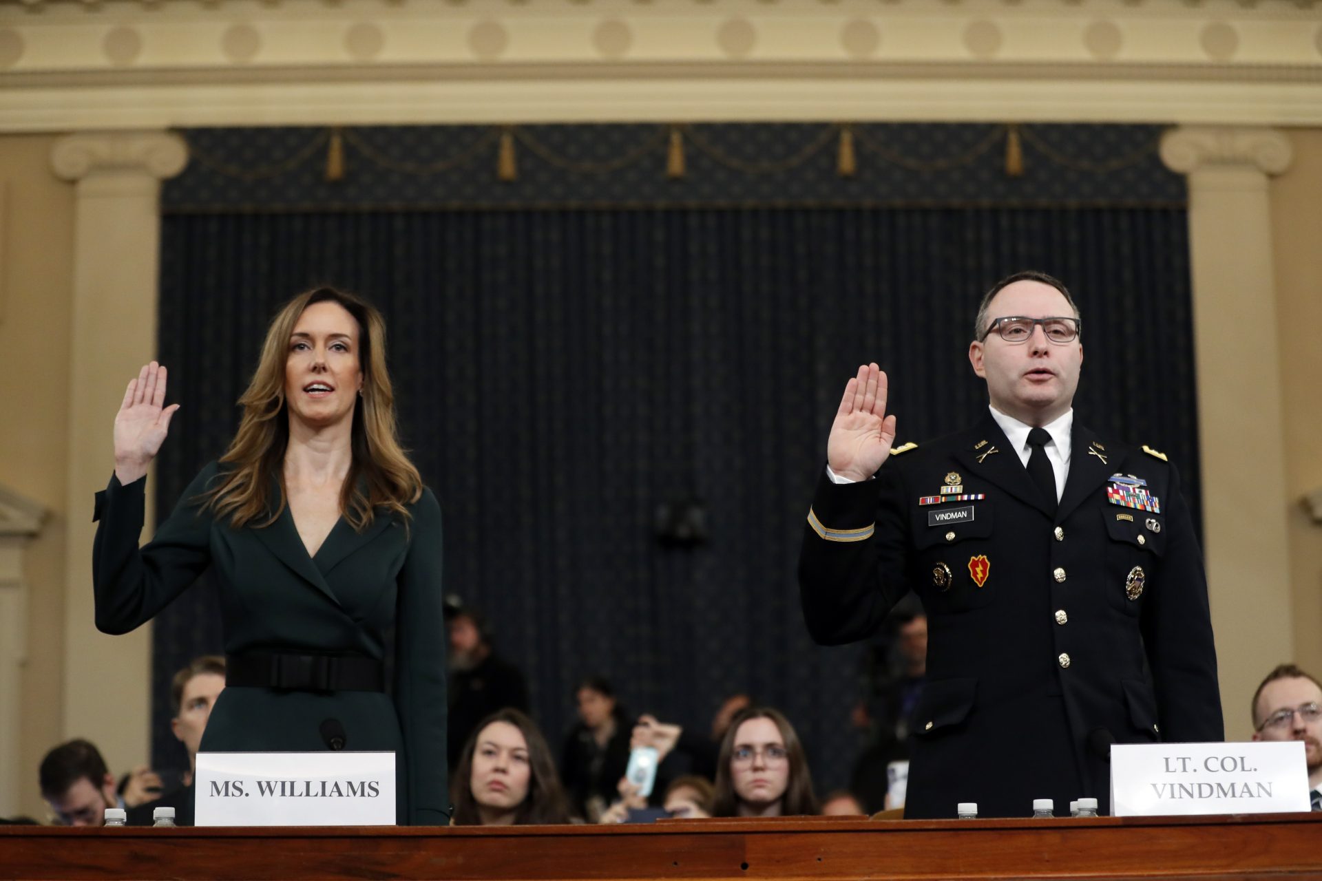 Jennifer Williams, an aide to Vice President Mike Pence, left, and National Security Council aide Lt. Col. Alexander Vindman, are sworn in to testify before the House Intelligence Committee on Capitol Hill in Washington, Tuesday, Nov. 19, 2019, during a public impeachment hearing of President Donald Trump's efforts to tie U.S. aid for Ukraine to investigations of his political opponents.