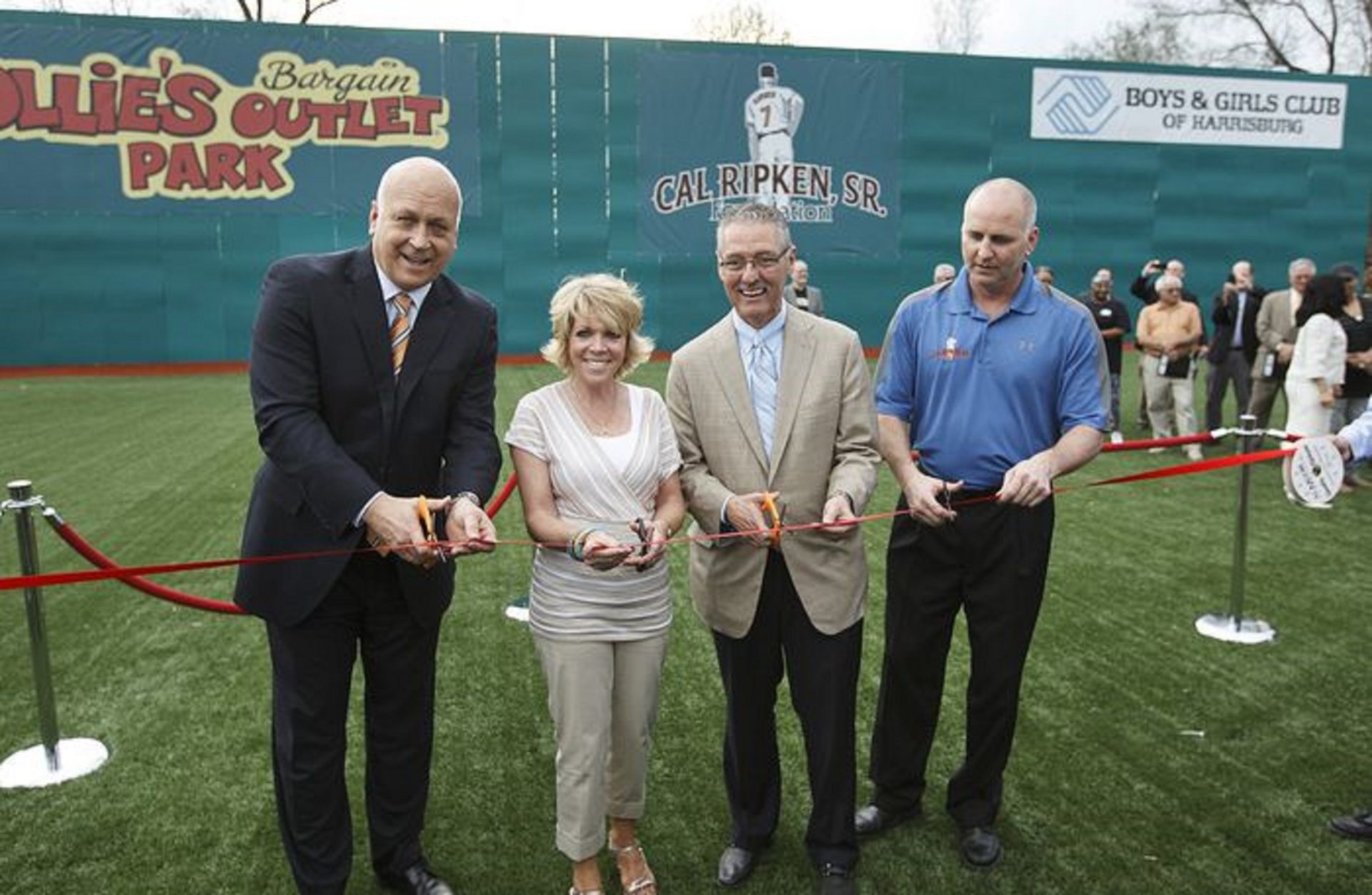 A ribbon cutting is held to commemorate the opening of the Mark and Betty Butler Field at Ollie's Bargain Outlet Park at the Boys and Girls Club of Harrisburg. Cutting the ribbon is Cal Ripken Jr., Betty Butler, husband Mark Butler, president and CEO of Ollies, and Bill Ripken. 04/10/2013