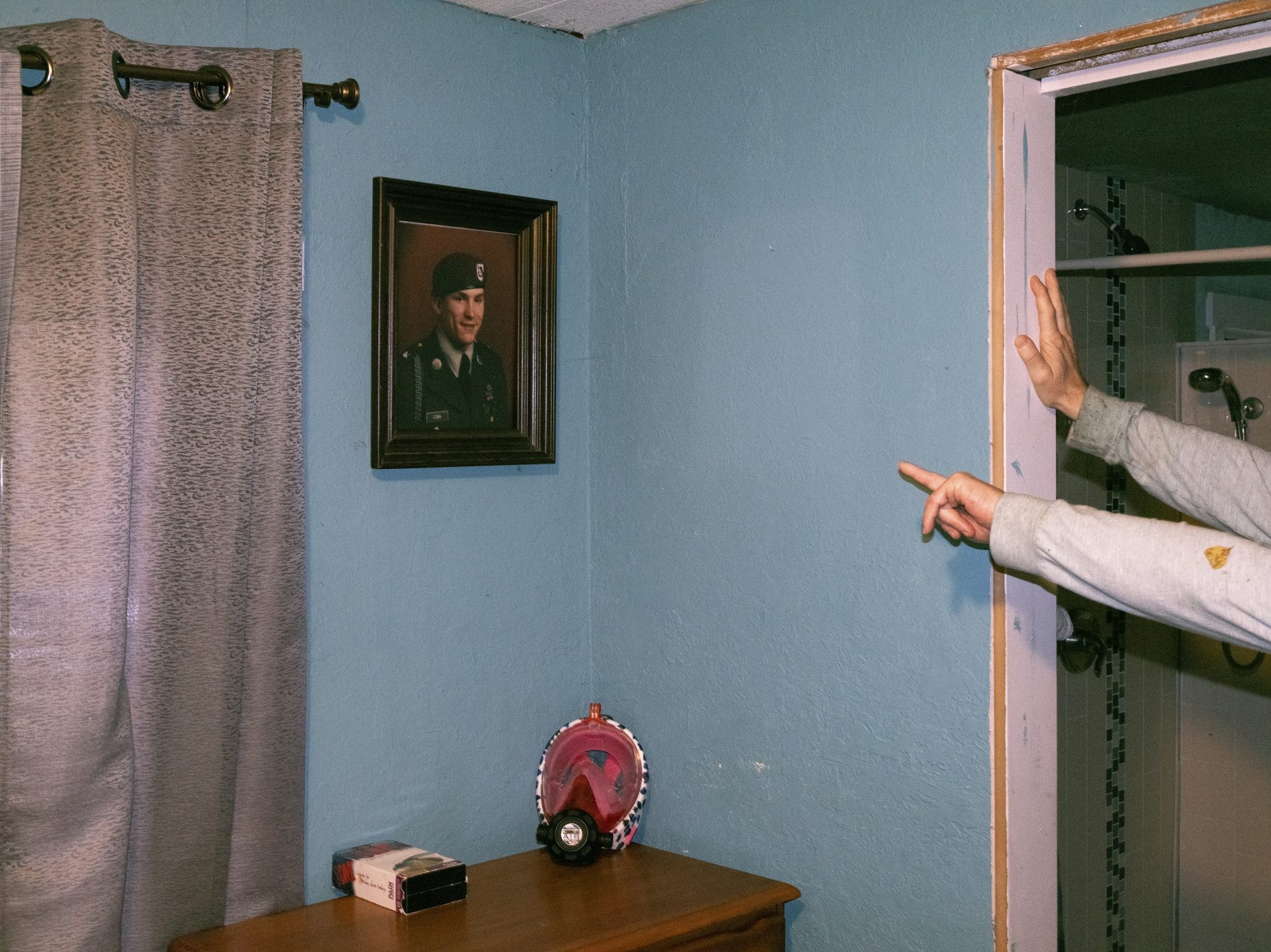 Chuck's military service photo hangs on the wall of his bedroom in his mother's house in Shelton, a reminder of his life before being incarcerated.