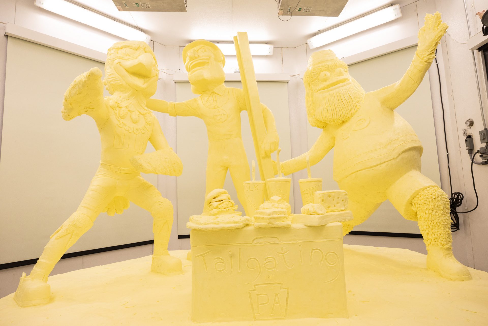 The 2020 Pennsylvania Farm Show butter sculpture, carved from a half-ton of butter, depicts three of Pennsylvania’s beloved professional sports mascots: Philadelphia Flyers’ Gritty, Philadelphia Eagles’ Swoop, and Pittsburgh Steelers’ Steely McBeam celebrating with a spread of Pennsylvania dairy products.