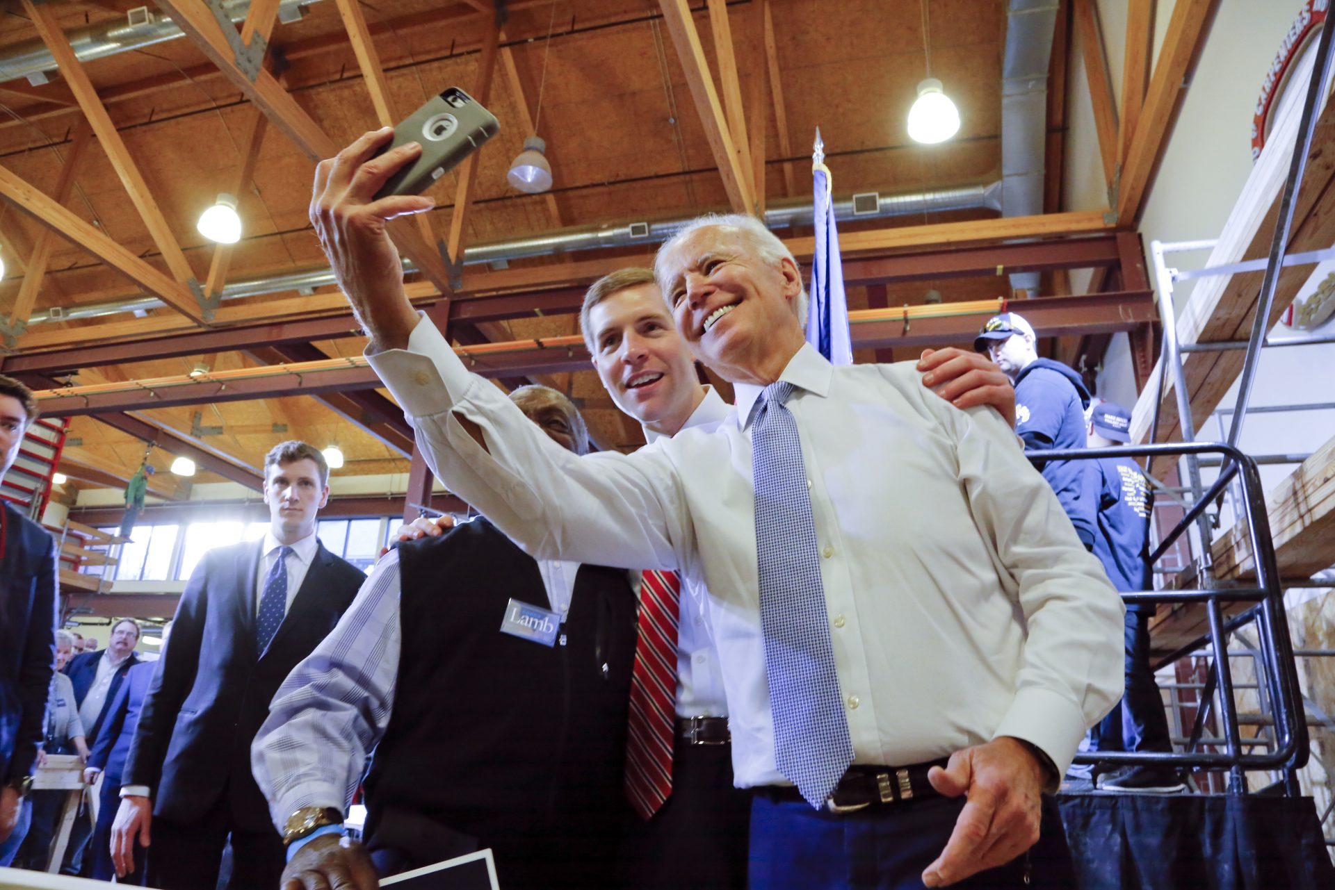 Conor Lamb, center, then a Democratic candidate for the March 13 special election in Pennsylvania's 18th Congressional District, and former Vice President Joe Biden, right, pose for a selfie with a supporter during a rally at the Carpenter's Training Center in Collier, Pa., Tuesday, March 6, 2018.