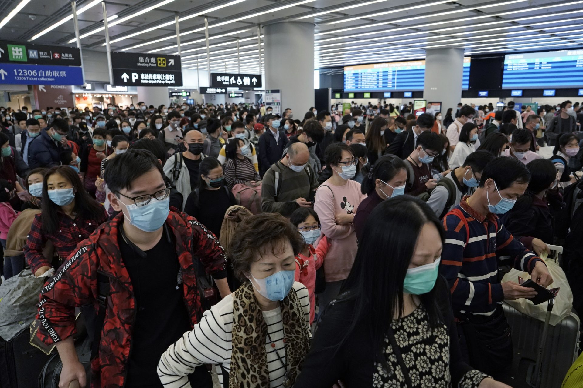 FILE - In this Thursday, Jan. 23, 2020 file photo, Passengers wear protective face masks at the departure hall of the high speed train station in Hong Kong. Fear about the effects of a new virus found in China is spreading faster through financial markets around the world than the sickness itself. U.S. stocks fell to their biggest weekly loss since early October on worries that the new coronavirus could ultimately hurt travel and global economic growth.