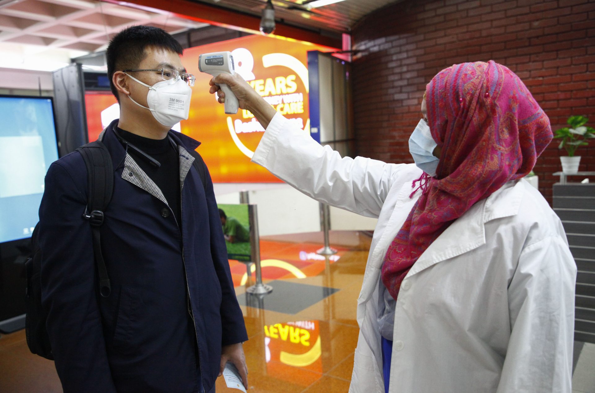 A passenger from Beijing is screened as part of measures to prevent coronavirus infection at Hazrat Shahjalal International airport in Dhaka, Bangladesh, Wednesday, Jan.29, 2020.