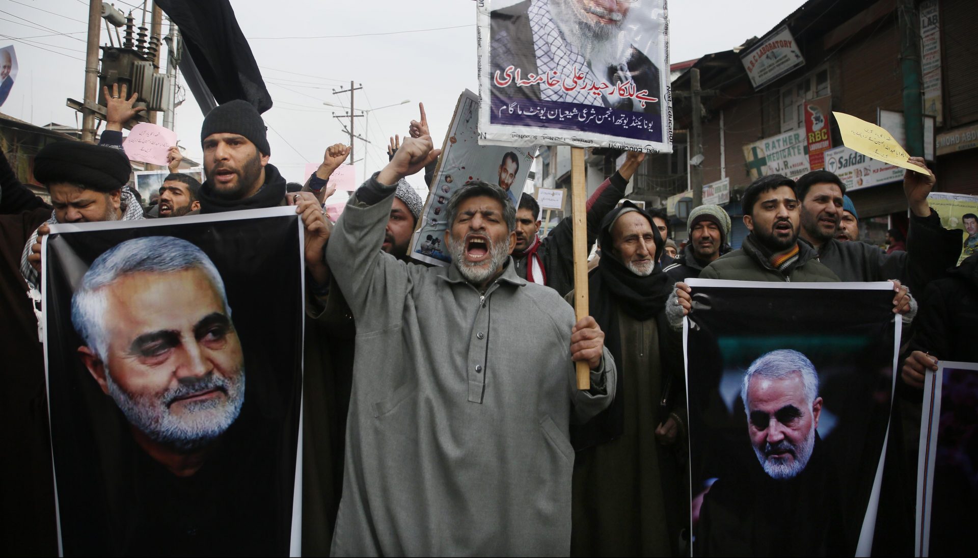 Kashmiri Shiite Muslims shout anti American and anti Israel slogans during a protest against U.S. airstrike in Iraq that killed Iranian Revolutionary Guard Gen. Qassem Soleimani, seen in the photographs, at Magam 37 kilometers (23 miles) north of Srinagar, Indian controlled Kashmir, Friday, Jan. 3, 2020. The killing of Iran's top military commander Gen. Qassem Soleimani triggered several anti-U.S. protests in Indian-controlled Kashmir, the protesters also shut down shops and businesses in Magam and Budgam towns in south Kashmir.