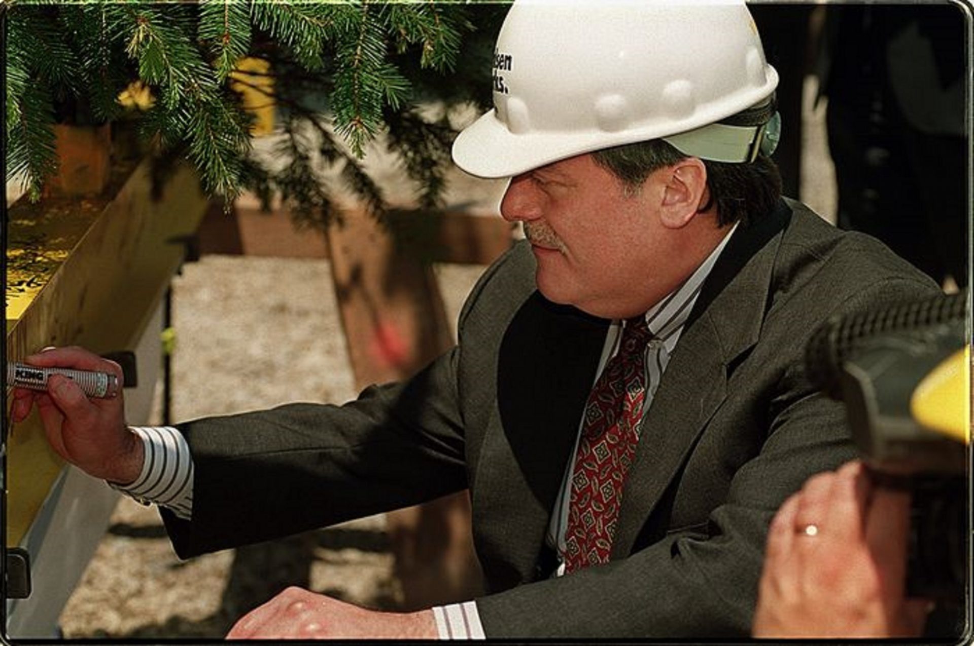 Harrisburg Mayor Stephen R. Reed signs his name on the 10-foot steel beam adorned with flags and an evergreen tree that was hoisted to the top of the Whitaker Center for Science and the Arts. The "topping off" ceremony marked the completion of the building's steel structure, May 15, 1998.