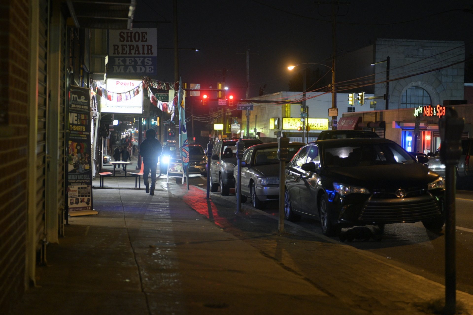 People stroll past shops as they close for the night at the commercial corridor on the 5500 block of North Fifth Street, on Tuesday.