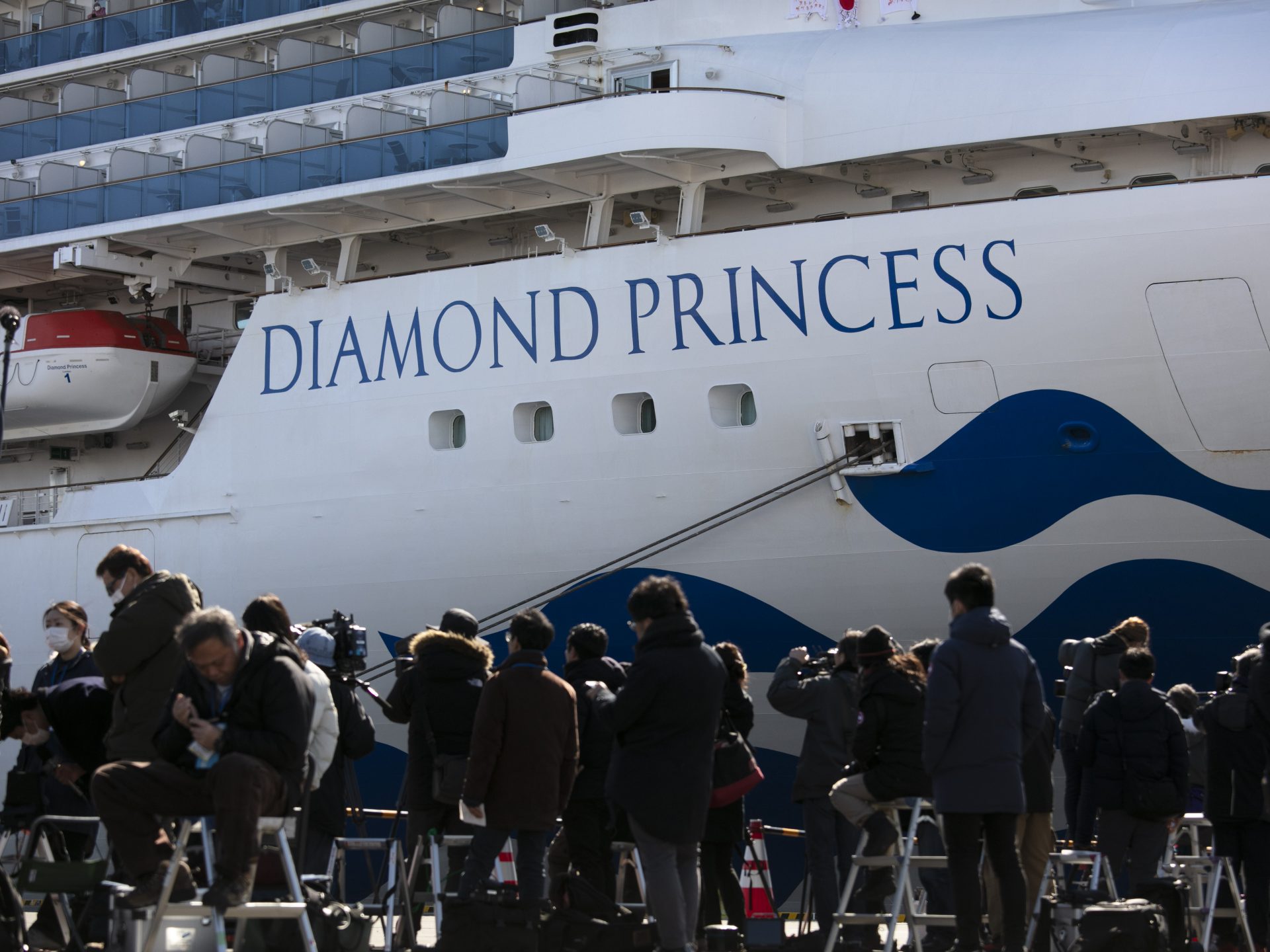 Media gather outside the quarantined Diamond Princess cruise ship in Yokohama, near Tokyo, on Tuesday. Japan's Health Ministry announced 65 new confirmed cases of the deadly coronavirus on the ship.