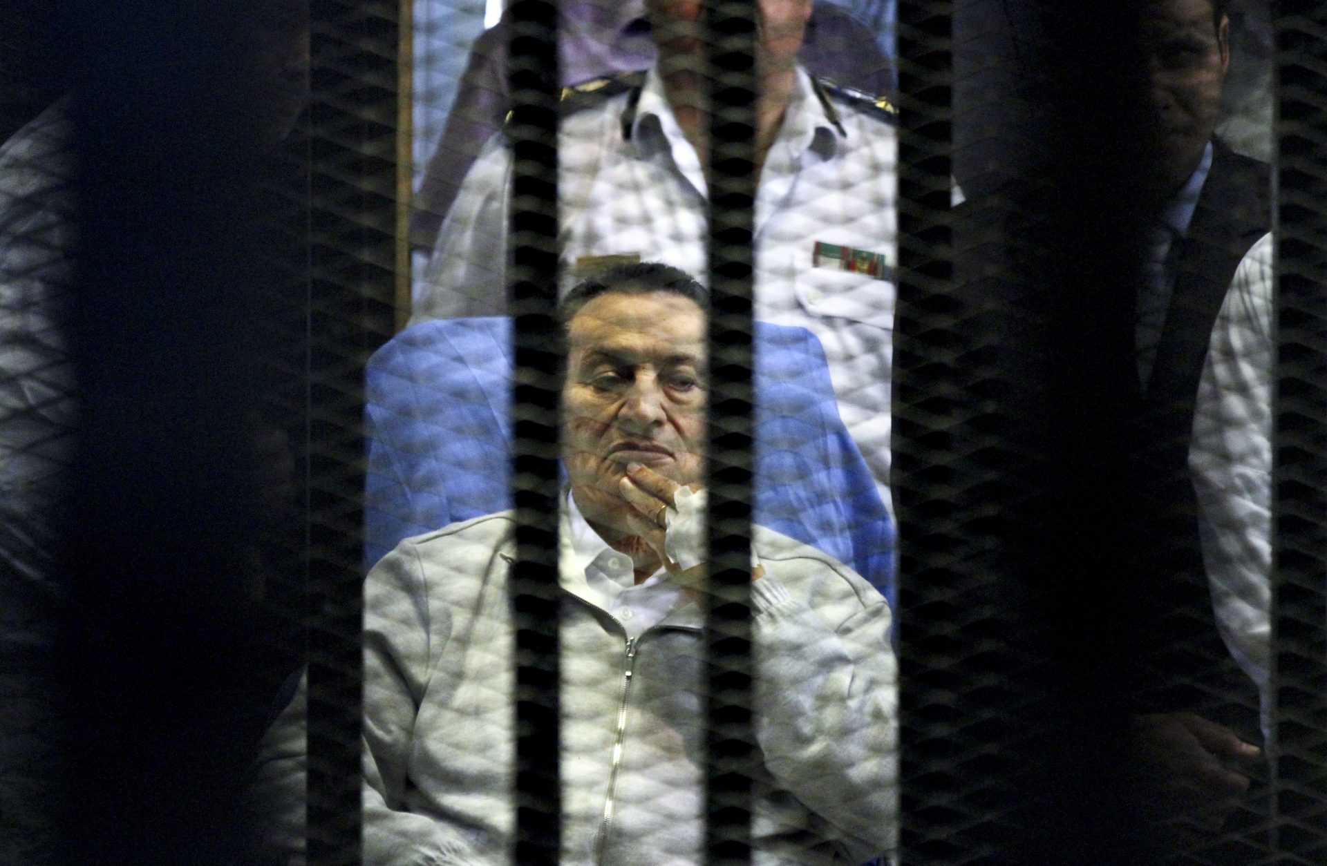 Egypt's deposed President Hosni Mubarak attends a hearing session in his retrial on appeal in Cairo, Egypt, Monday, April 15, 2013. Mubarak will remain in custody on new corruption charges despite a court order to release him on bail pending his retrial on charges related to killing of protesters in the 2011 uprising against him, Egypt’s state news agency said Monday.