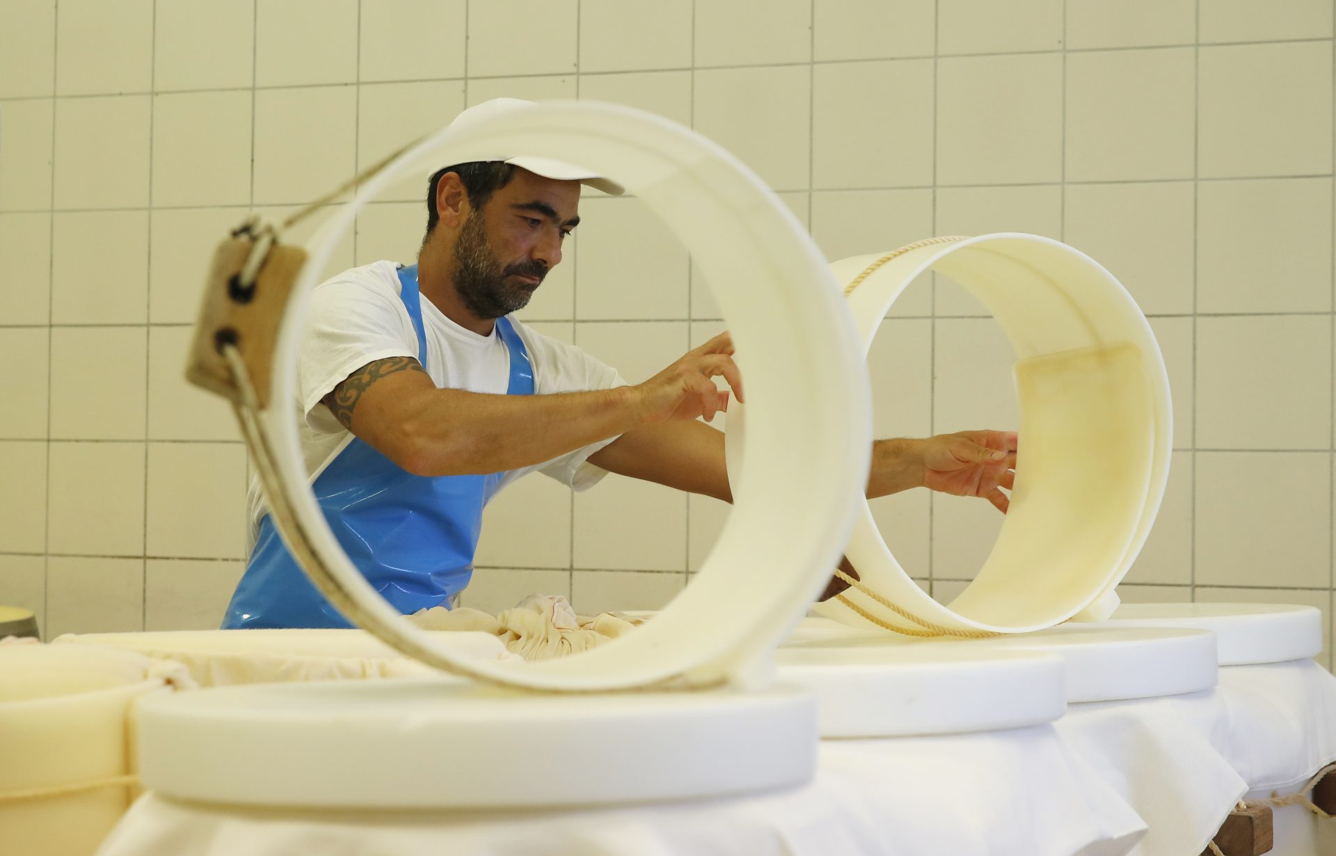 In this photo taken Tuesday, Oct. 8, 2019, Parmigiano Reggiano Parmesan cheese wheels are created in Noceto, near Parma, Italy. U.S. consumers are snapping up Italian Parmesan cheese ahead of an increase in tariffs to take effect next week. The agricultural lobby Coldiretti on Friday, Oct. 11, 2019, said sales of both Parmigiano Reggiano and Grana Padano, aged cheeses defined by their territory of origin, have skyrocketed by 220% since the higher tariffs were announced one week ago.