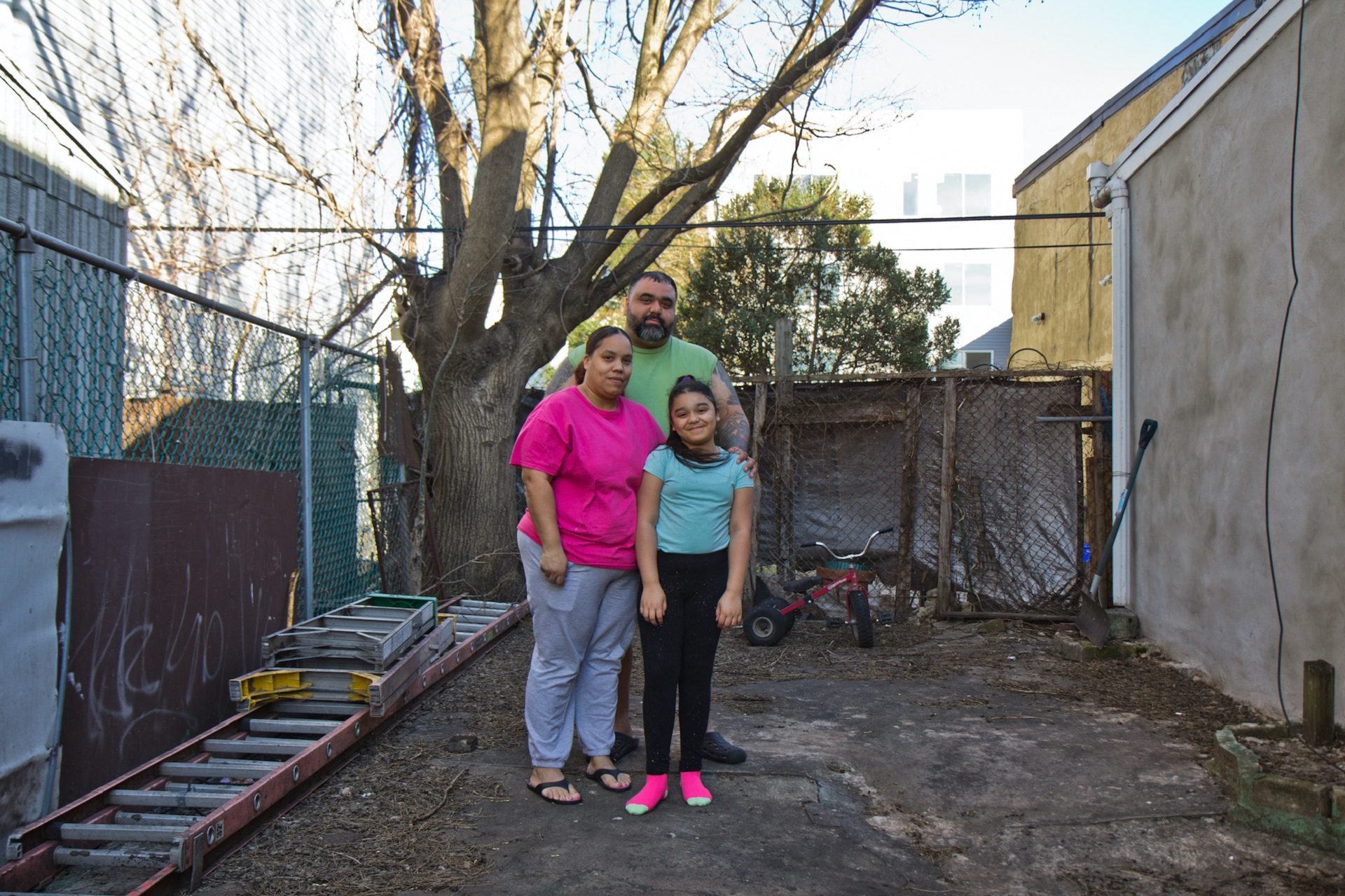 Adamarie Baez and Daniel Ortiz with their ten year-old daughter Kaylee in the lot next to their home they’ve maintained and gardened in for years.