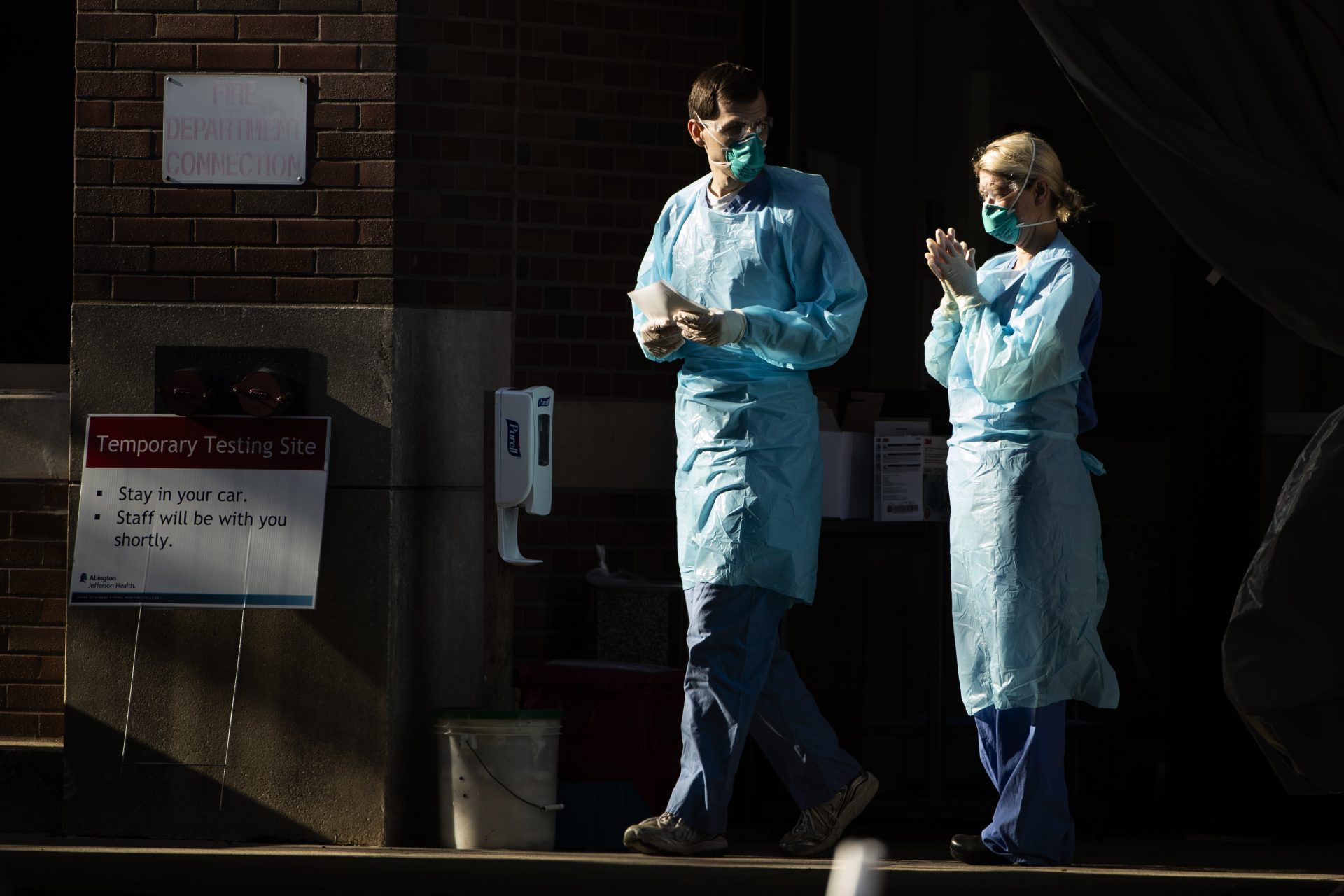 Healthcare workers stand by at a COVID-19 temporary testing site at Abington Hospital in Abington, Pa., Wednesday, March 18, 2020. For most people, the new coronavirus causes only mild or moderate symptoms. For some it can cause more severe illness.
