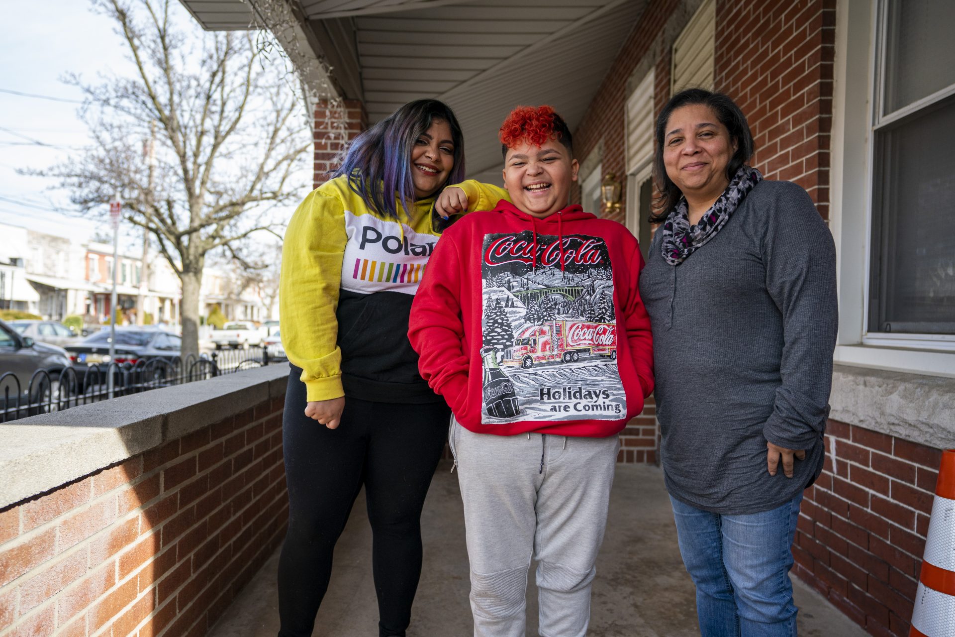 Yali Perez (left), her son Ian and her mother Brenda Santiago on their porch in Bridesburg. Although still wary, Yali says she has a "love affair" with the neighborhood because of its lack of crime.