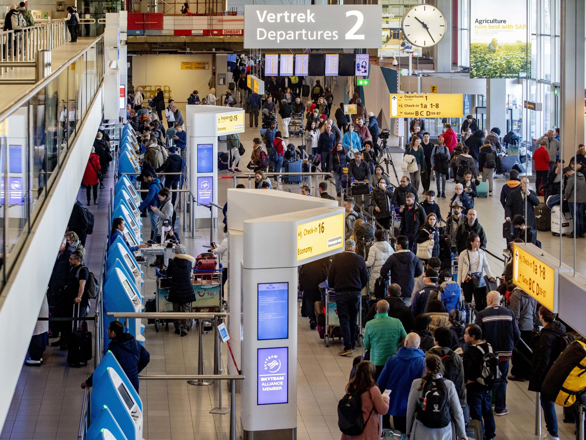 Passengers hoping to change their flights to the U.S. wait in long lines at the Schiphol Airport in the Netherlands, after President Trump announced new restrictions on travel from Europe.