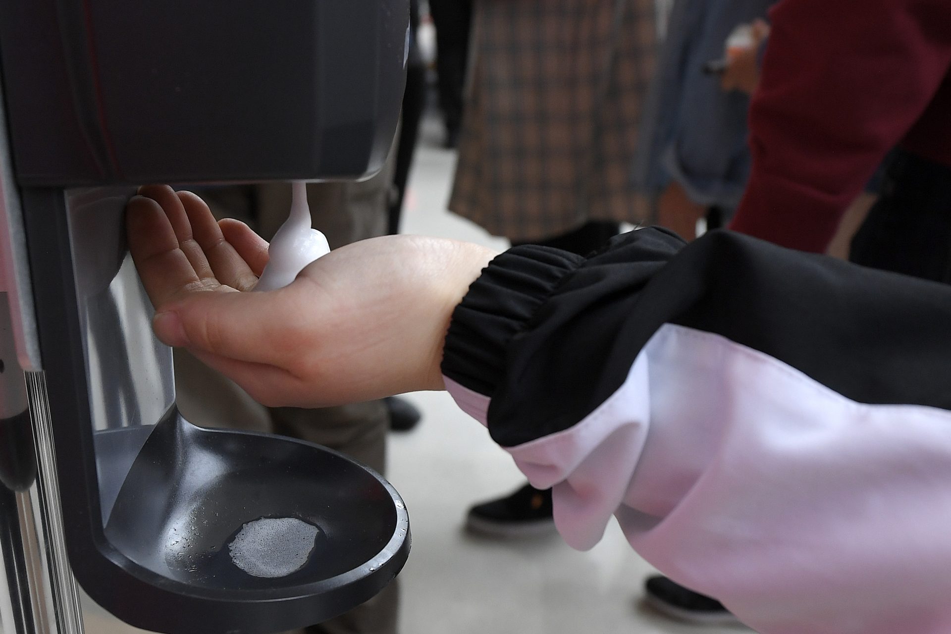 A fan uses a sanitizing station at Staples Center prior to an NBA basketball game between the Los Angeles Clippers and the Philadelphia 76ers Sunday, March 1, 2020, in Los Angeles.
