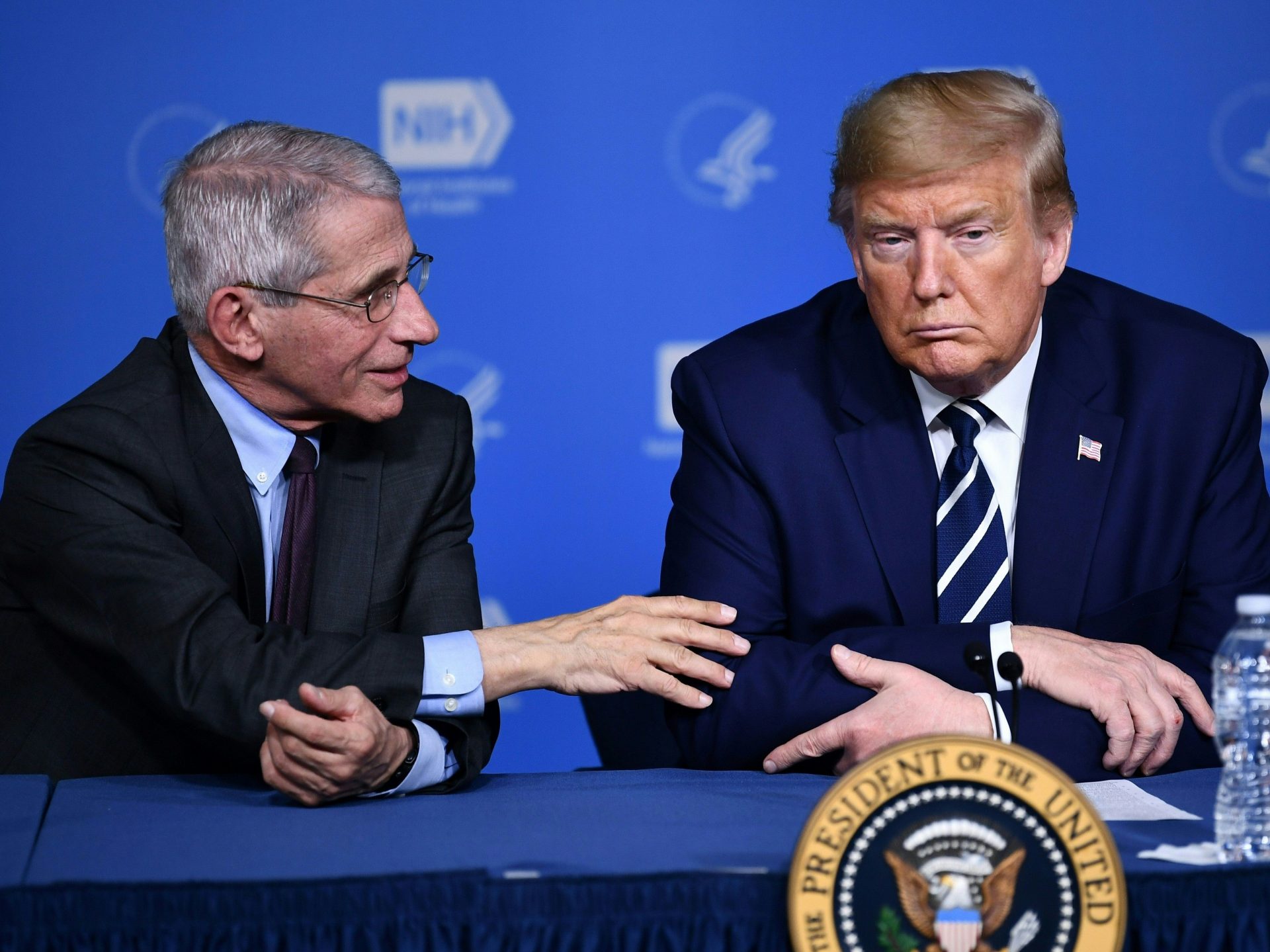 President Trump listens to Anthony Fauci, director of the NIH National Institute of Allergy and Infectious Diseases, after a tour earlier this week.