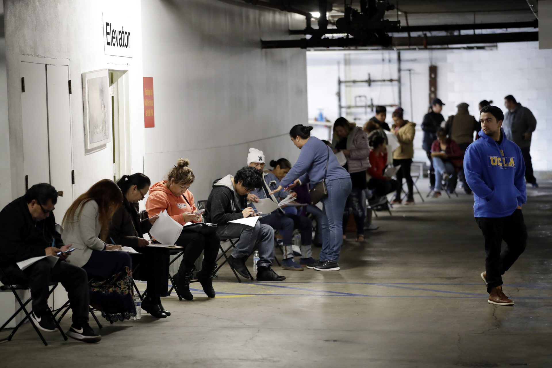 Unionized hospitality workers wait in line in a basement garage to apply for unemployment benefits at the Hospitality Training Academy Friday, March 13, 2020, in Los Angeles. Fearing a widespread health crisis, Californians moved broadly Friday to get in front of the spread of the coronavirus, shuttering schools that educate hundreds of thousands of students, urging the faithful to watch religious services online and postponing or scratching just about any event that could attract a big crowd.