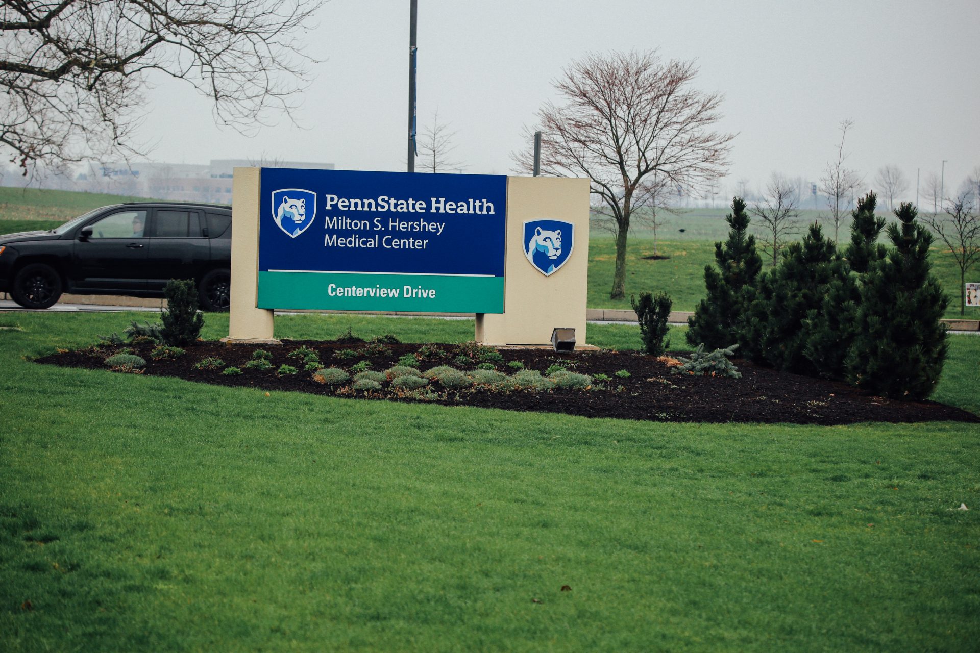 A car passes behind the entrance sign at Penn State Health's Milton S. Hershey Medical Center on April 1, 2020.