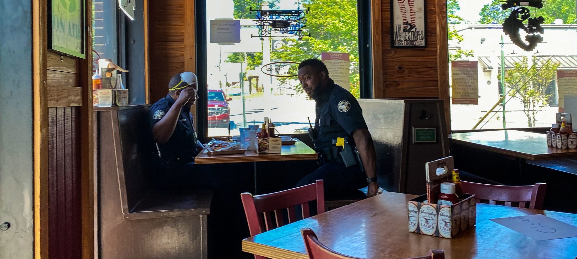 Two police officers siting at a table, eat at Moe's Original BBQ restaurant amid the coronavirus pandemic on April 27 in Atlanta, Ga. Some Georgia restaurants reopened on April 27 for limited dine-in service as the state loosened more coronavirus restrictions.