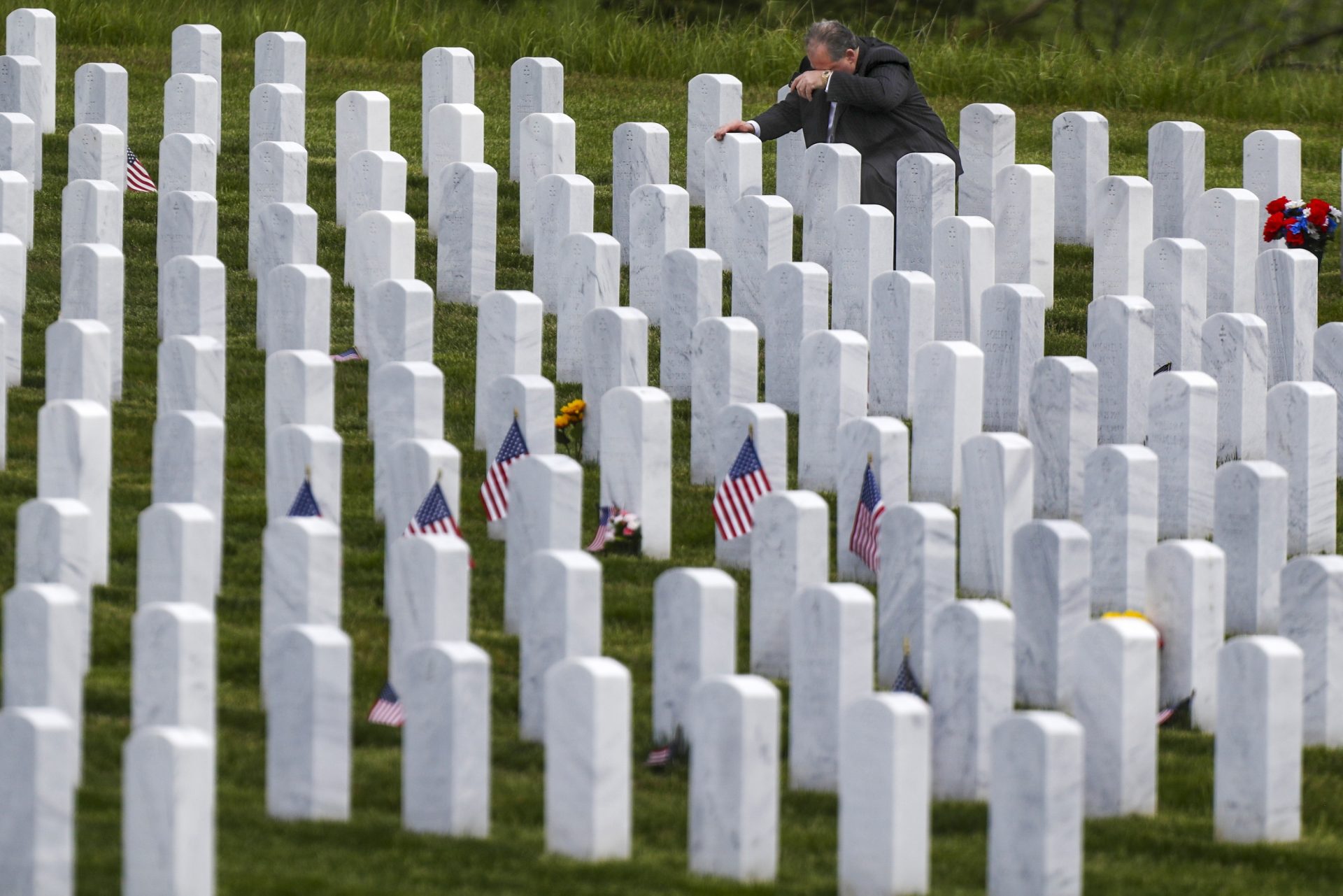 Raymond Piacquadio wipes his brow as he kneels at the grave of his mother during his visit to the Cemetery of the Alleghenies, a Veterans Administration National Cemetery, Saturday, May 23, 2020, on the Memorial Day Holiday weekend in Bridgeville, Pa.