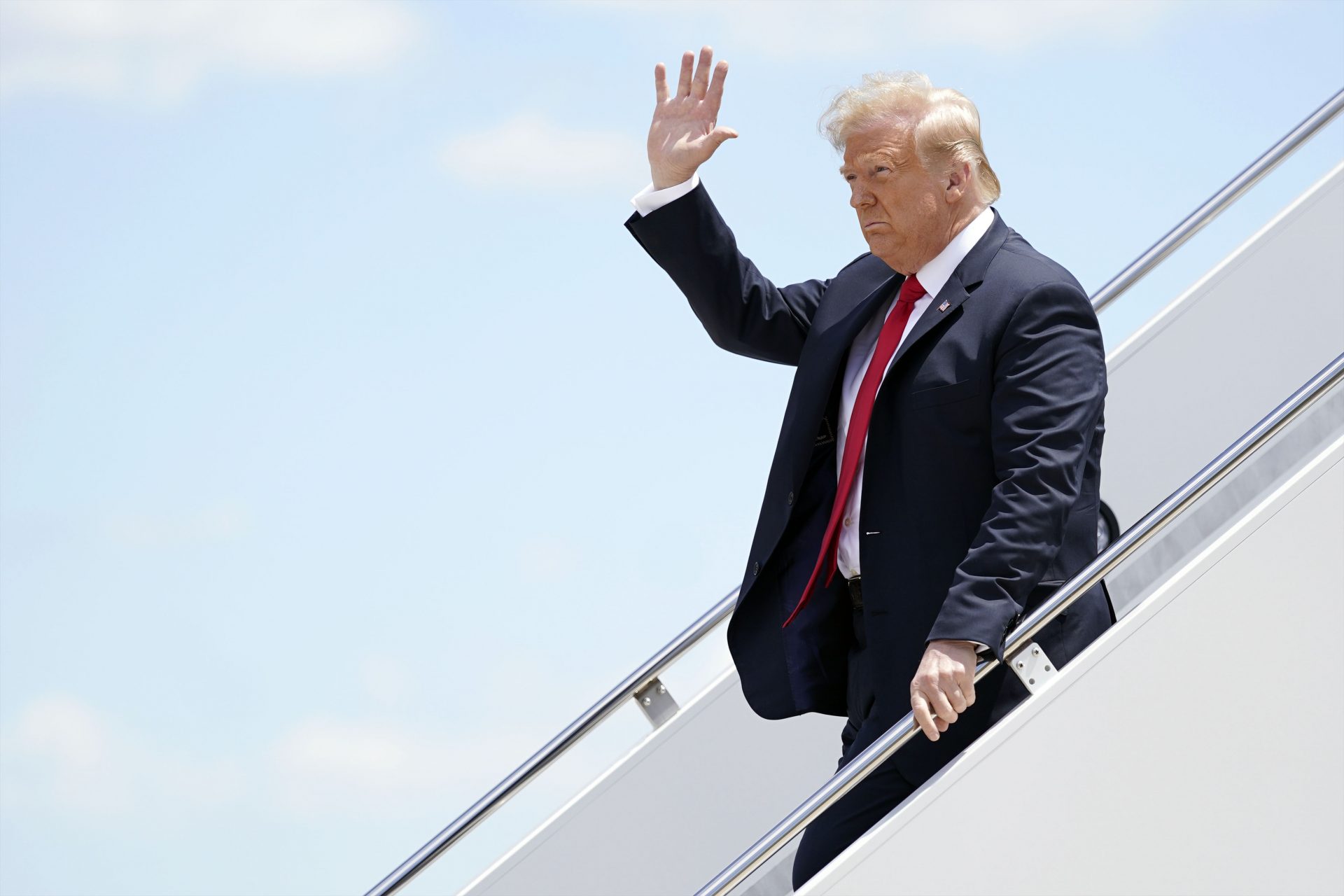 President Donald Trump waves as he arrives on Air Force One at Austin Straubel International Airport in Green Bay, Wis., Thursday, June 25, 2020.