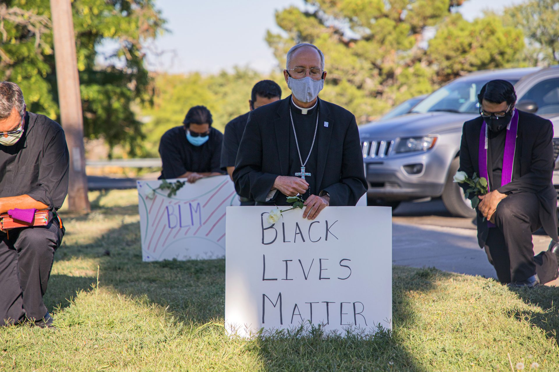 In this June 1, 2020, photo provided by the Catholic Diocese of El Paso, Bishop Mark Seitz, center, kneels with other demonstrators at Memorial Park holding a Black Lives Matter sign in El Paso, Texas. Pope Francis called Seitz unexpectedly after he was photographed at the protest.