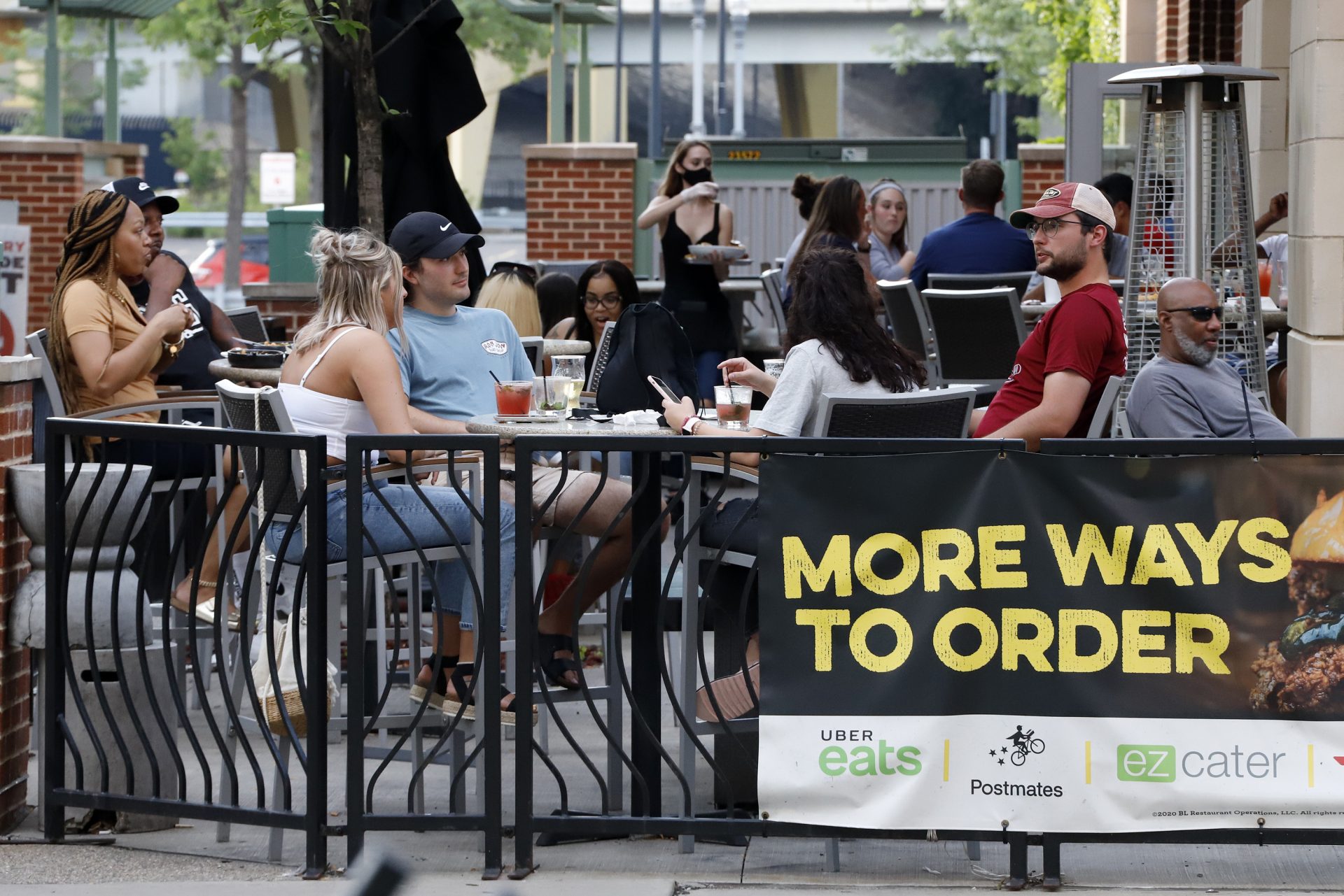People gather at tables outside Bar Louie on the Northside of Pittsburgh Sunday, June 28, 2020. In response to the recent spike in COVID-19 cases in Allegheny County, health officials are ordering all bars and restaurants in the county to stop the sale of alcohol for on-site consumption beginning on June 30.