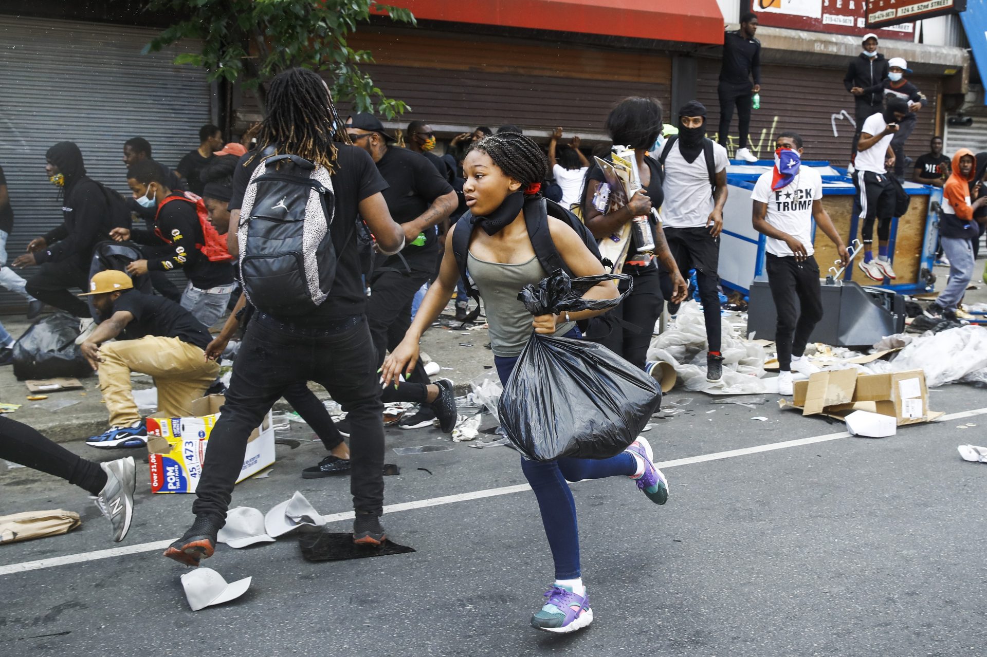 People run from the area as police officers approach stores that were broken into as protests continue on Sunday, May 31, 2020, in Philadelphia. Protests were held throughout the country over the death of Floyd, a black man who died after being restrained by Minneapolis police officers on May 25.