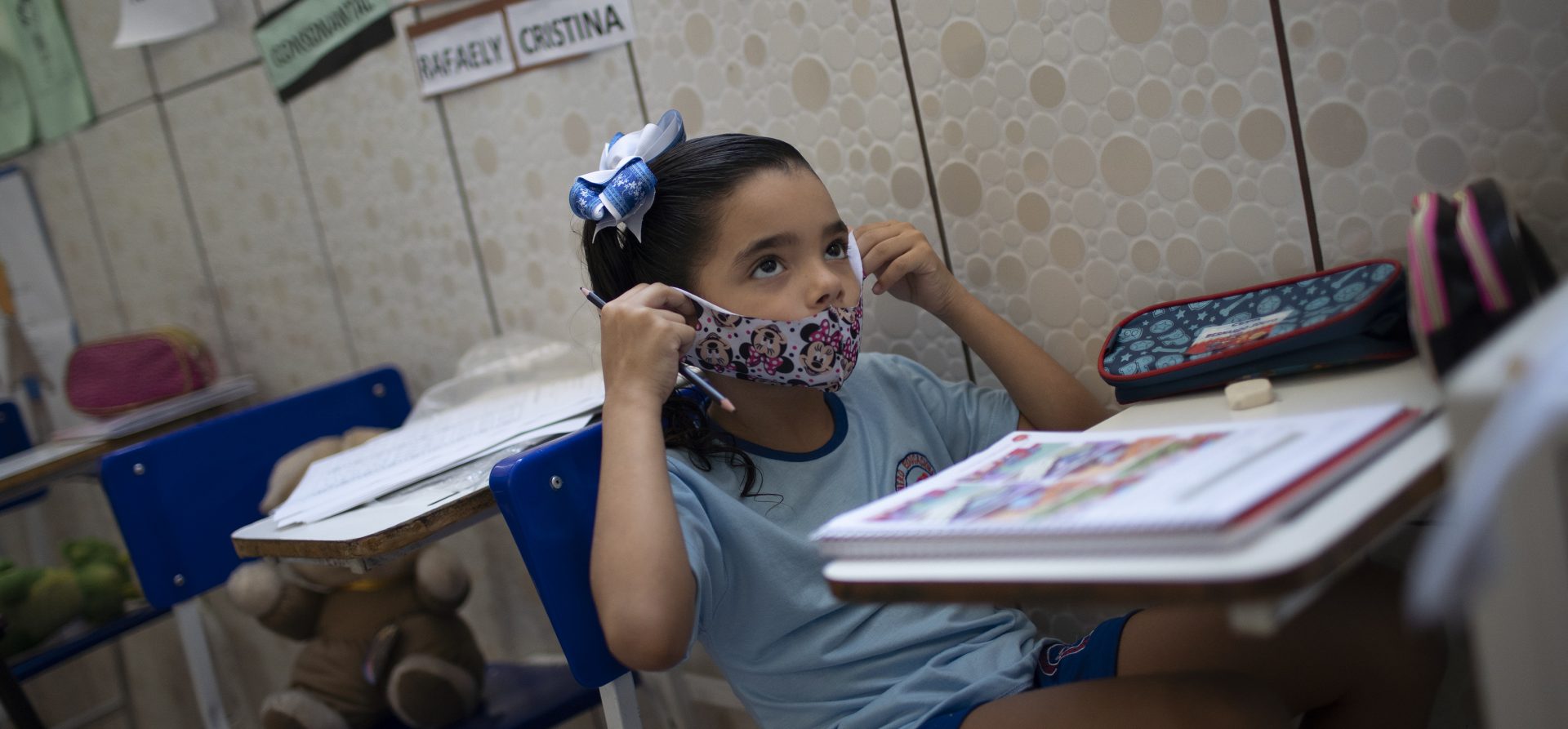 Rafaely de Melo puts on her protective mask during a class at the Pereira Agustinho daycare, nursery school and pre-school, after it reopened amid the new coronavirus pandemic in Duque de Caxias, Monday, July 6, 2020. The city of Manaus in the Amazon rainforest and Duque de Caxias in Rio de Janeiro’s metropolitan region, became on Monday the first Brazilian cities to resume in-person classes at private schools since the onset of the COVID-19 pandemic, according to the nation's private school federation.