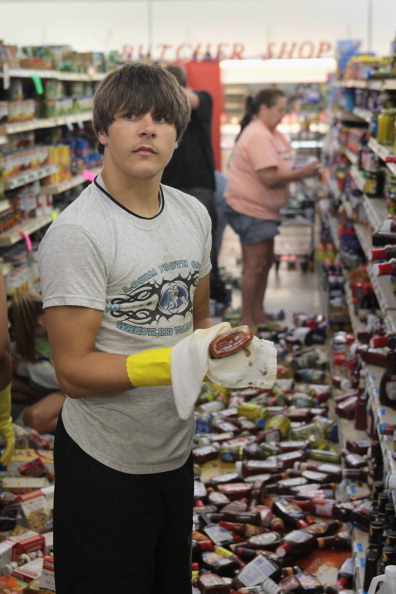 Brandon Bennington helps clean up after Tuesday's earthquake knocked food off supermarket shelves in Mineral, Va.