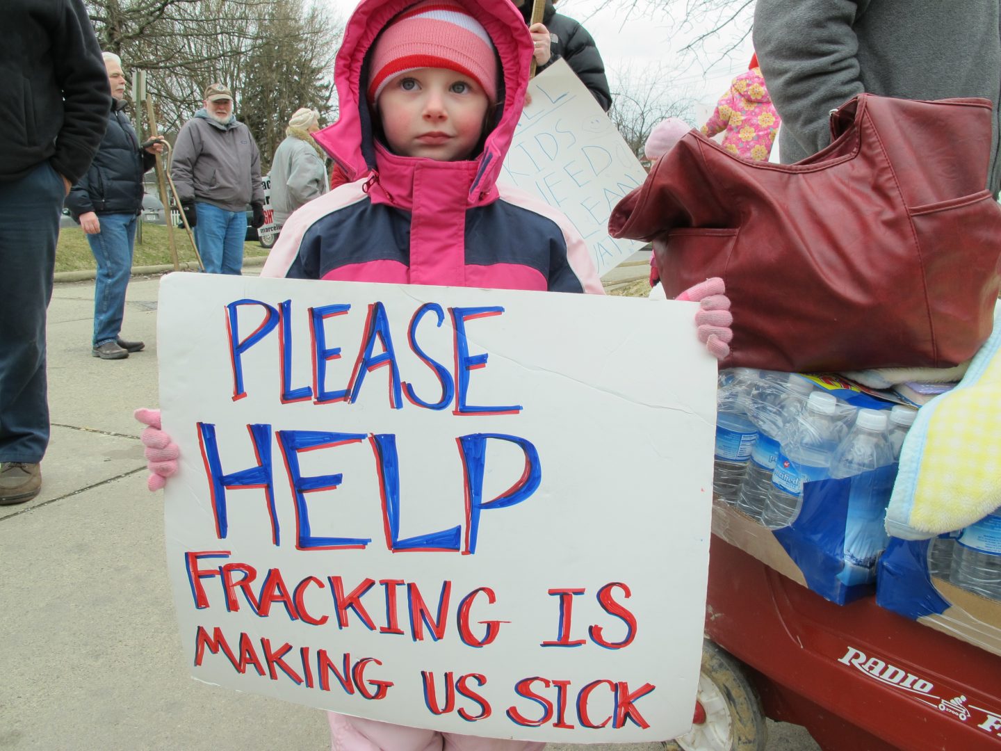 In this photo from 2012, Skylar McEvoy holds up a sign at a rally in Butler, Pa. She and her family moved after they say fracking polluted their water. 