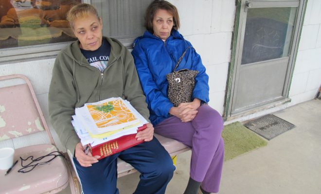 Jeanie Moten with her sister on their mother's porch in Rea, Pa. She holds a stack of medical records. The Motens say they received no help from DOH regarding their fracking health complaints. A case file released by the DOH through a Right-To-Know request confirmed that.