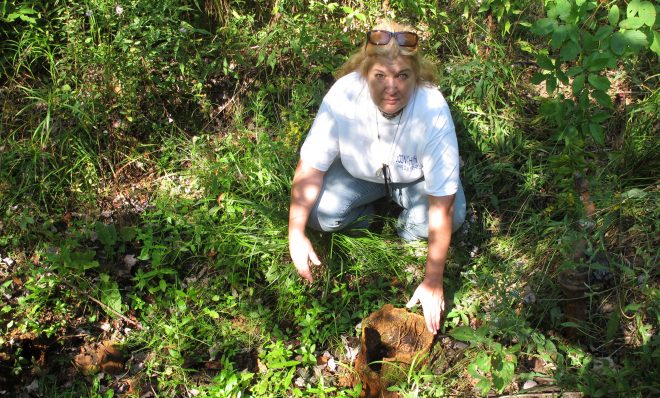 In this 2012 photo, Laurie Barr points to an abandoned well near the Allegheny National Forest.