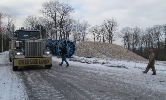 An oversize truck load of natural gas industry equipment moves slowly along an icy mountain road in the Tiadaghton state forest.