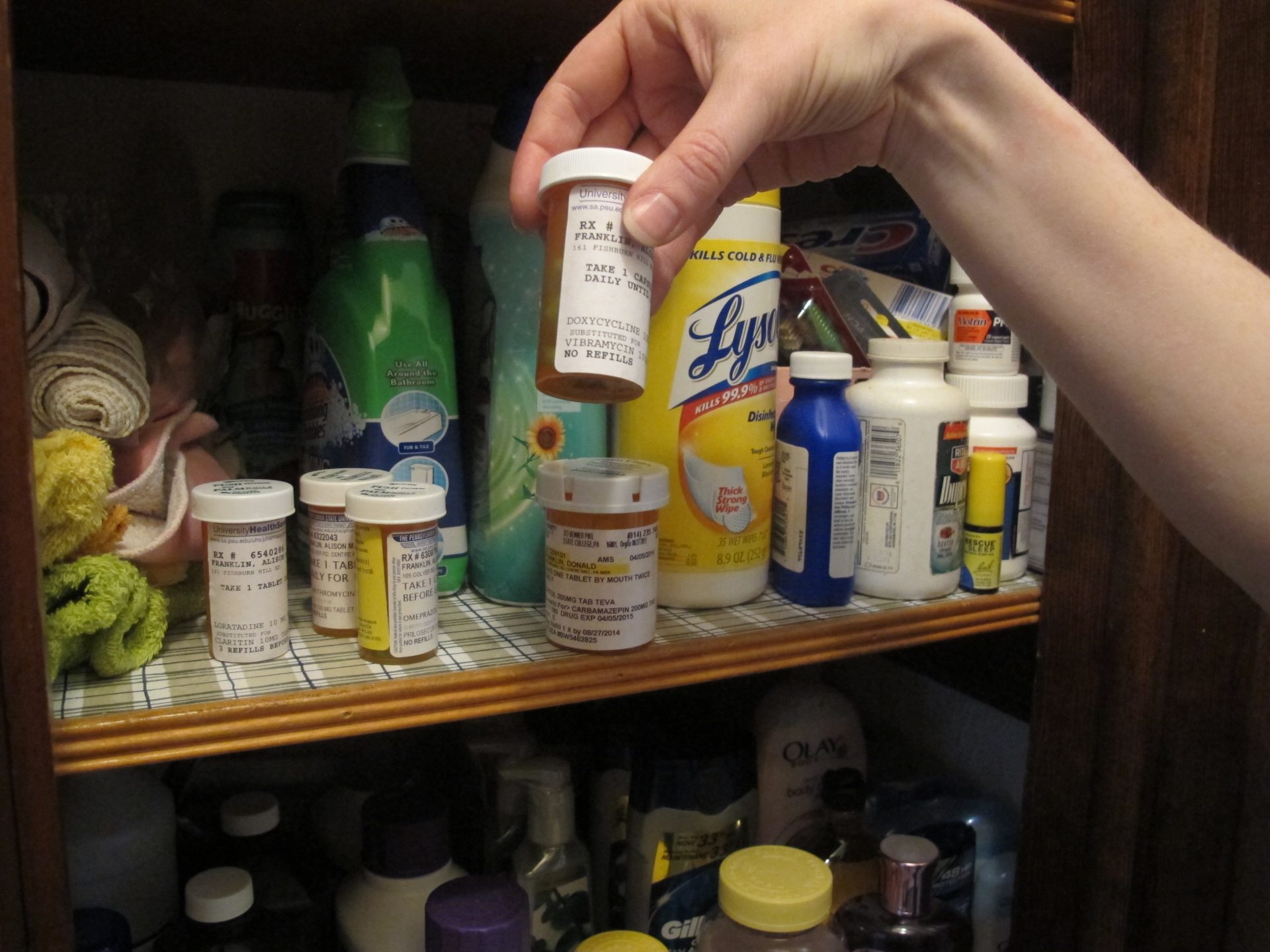 Penn State researcher Alison Franklin holds up one of five prescriptions in her closet at home in Bellefonte, Pa.