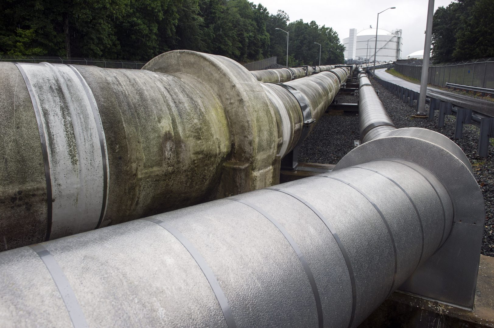 Transfer pipes carry liquified natural gas to and from a holding tank, seen in background, at Dominion Energy's Cove Point LNG Terminal in Lusby, Md., Thursday, June 12, 2014. 