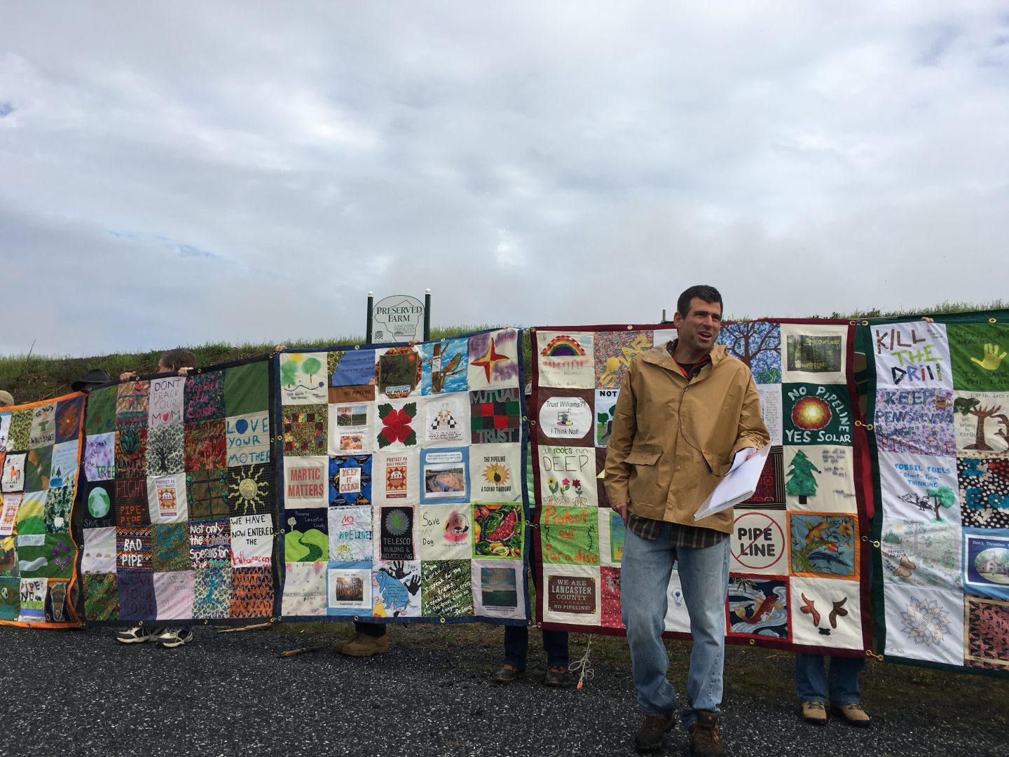 Mark Clatterbuck stands in front of a quilt designed to protest the Atlantic Sunrise pipeline.