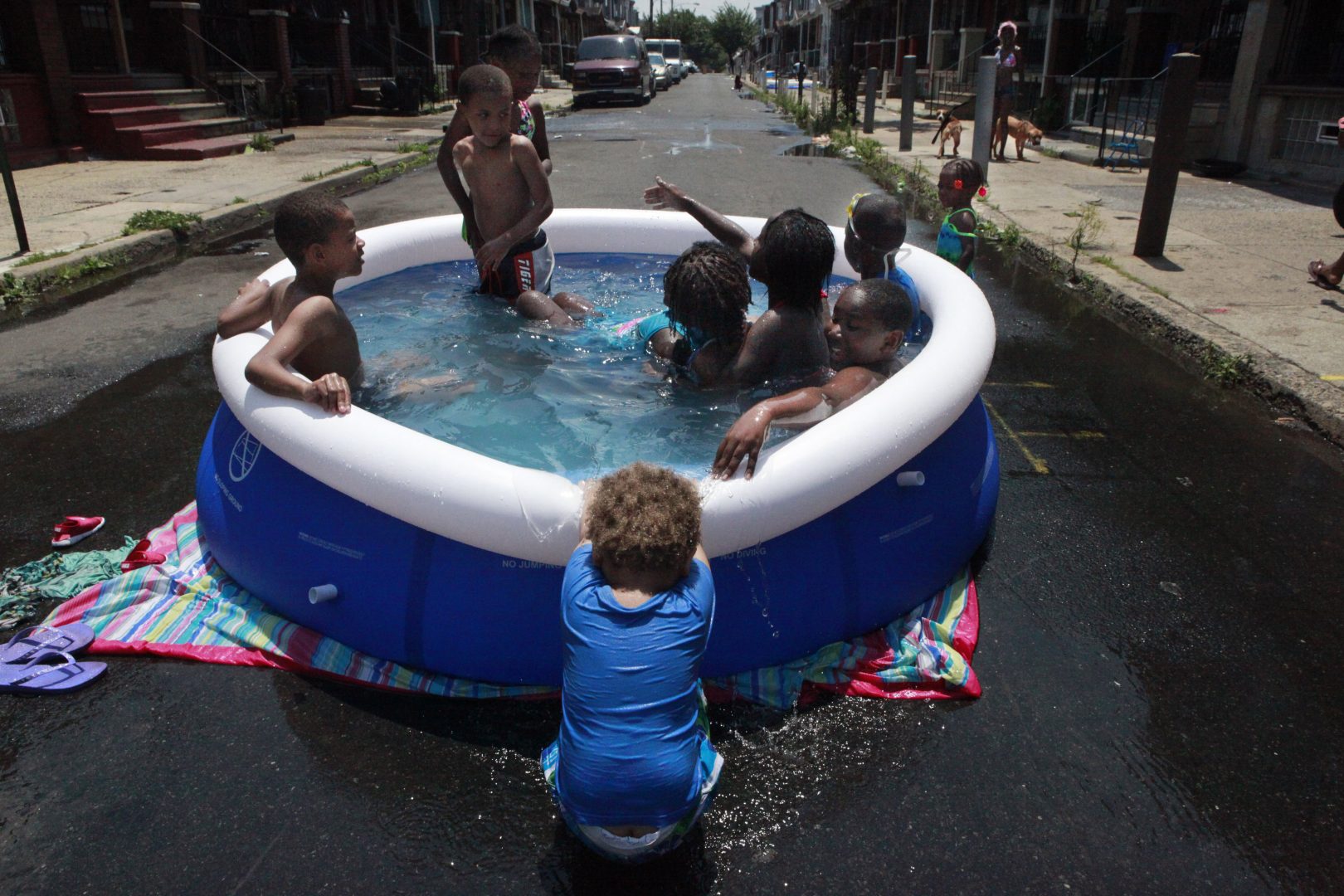 In this June 2012 photo, Michael Hall, 2, pulls down the edge of the pool while others swim  in Philadelphia. Climate change has already brought hotter weather to the state, where some areas have warmed 2 degrees in 30 years.