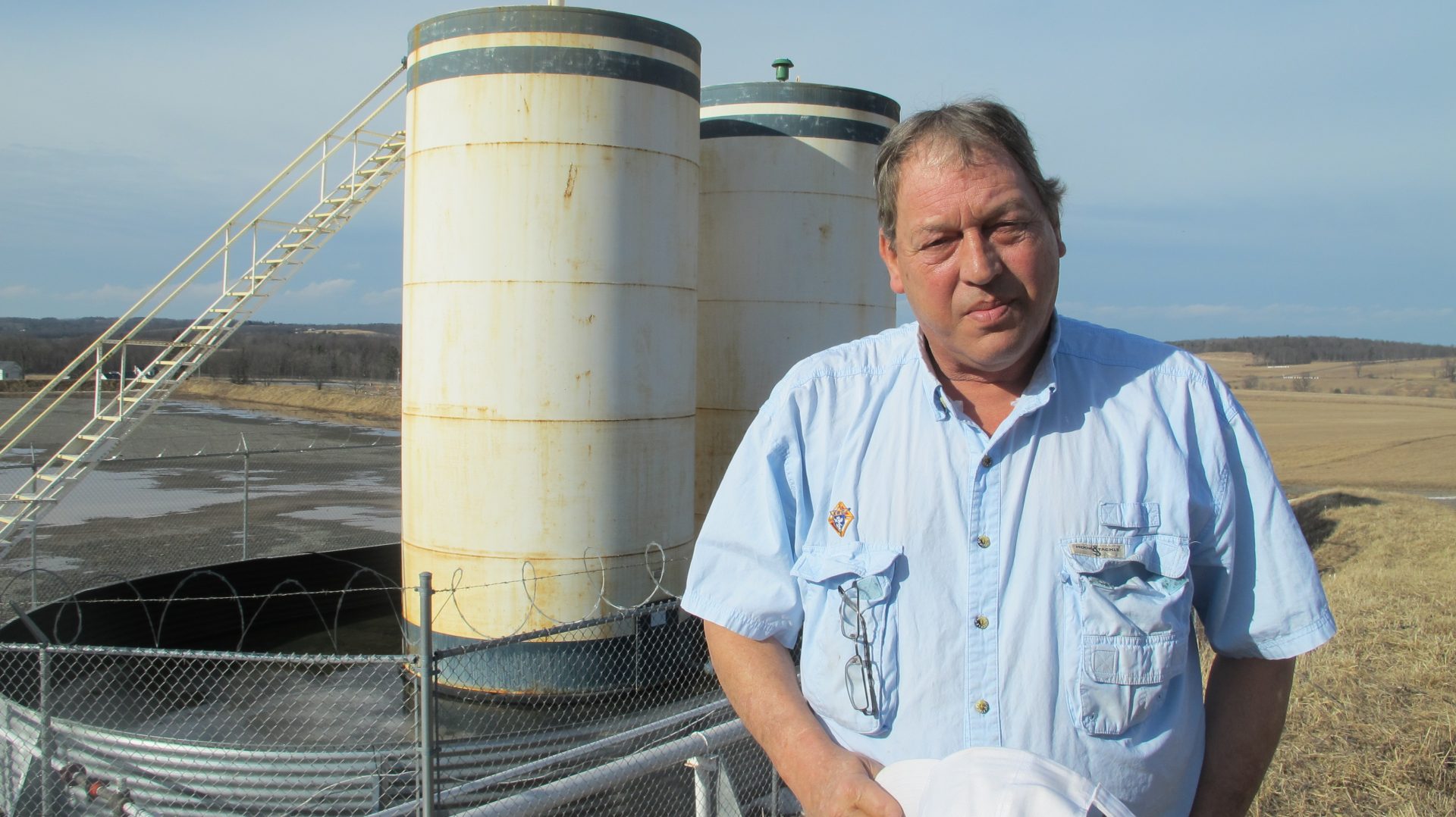 Jim Barrett stands next to a wellpad on his farm in Bradford County. He says Chesapeake Energy, which drilled four natural gas wells on his land, is cheating him out of royalty money. He is part of a class-action lawsuit against the company, which is separate from a case involving Chesapeake that's being pursued by the state Attorney General.