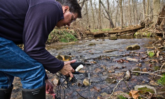 John Jackson, senior research scientist at the Stroud Water Research Center, measure conductivity in the White Clay Creek stream.