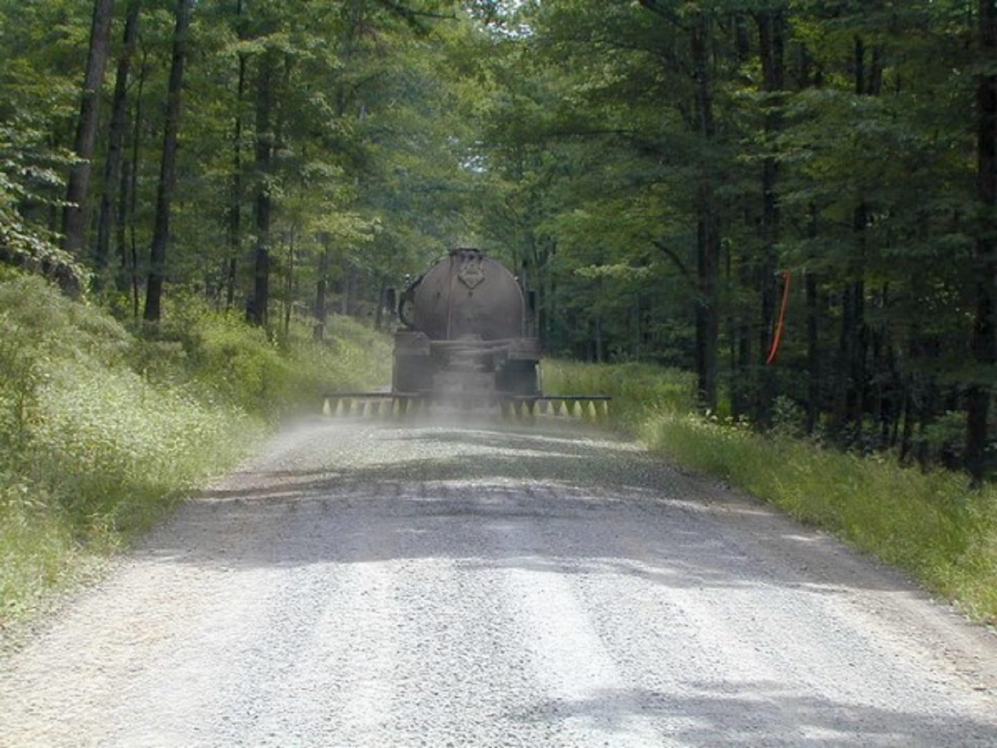 A truck sprays a dust suppressant on a dirt road in Pennsylvania. Some communities in Northwest Pennsylvania use conventional oil and gas waste as a suppressant. 