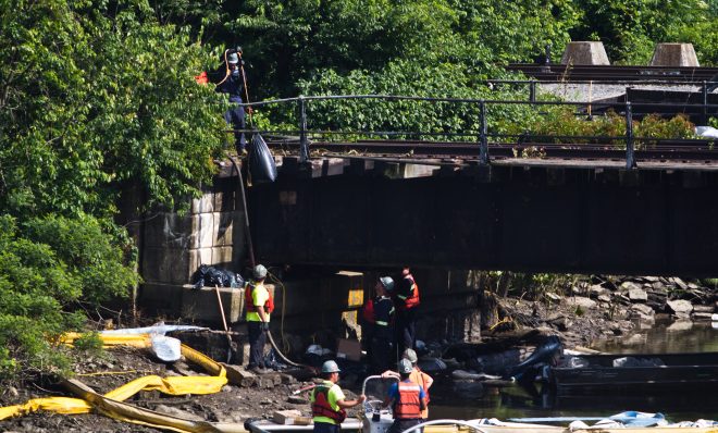 An environmental clean-up crew works to remove gasoline fuel from an ETP pipeline spill in Darby creek in Tinicum Township, Pa. (Kimberly Paynter/WHYY)