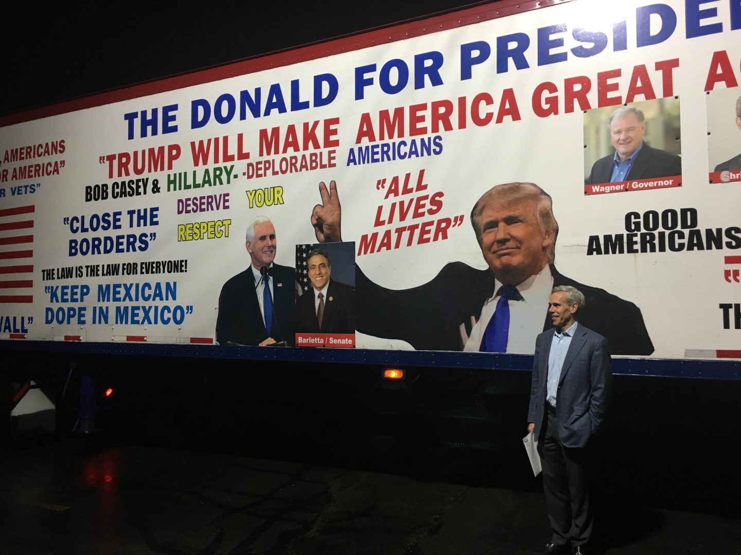 Republican congressional candidate John Chrin poses for a picture in front of a Donald Trump-themed tractor-trailer on Sept. 12, 2018 in Luzerne County.